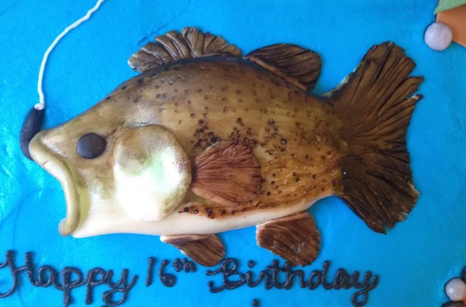 Fishing themed cake with edible pond, rod, and bass jumping from water