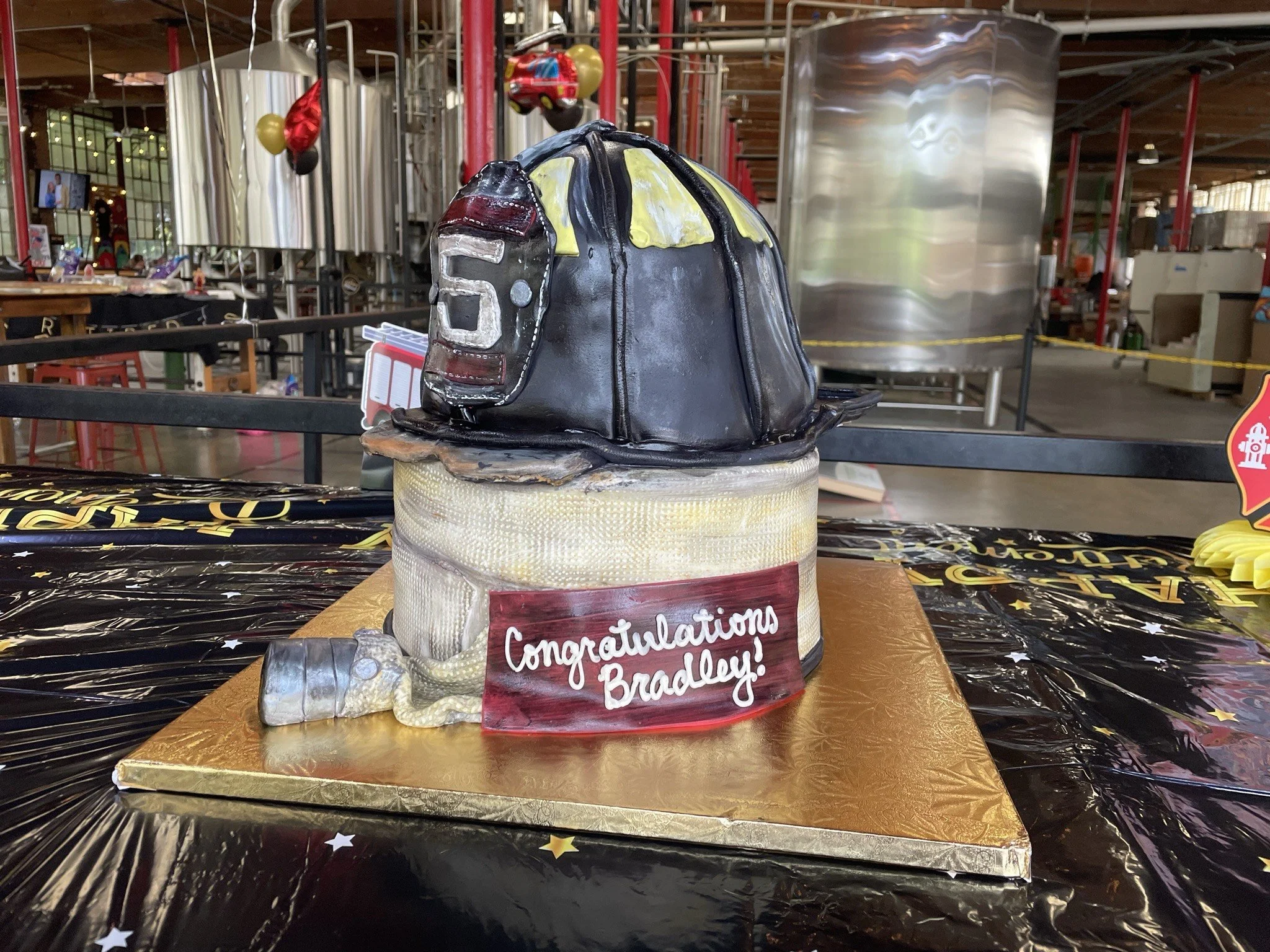 Two tier Firefighter retirement cake with helmet and fire hose