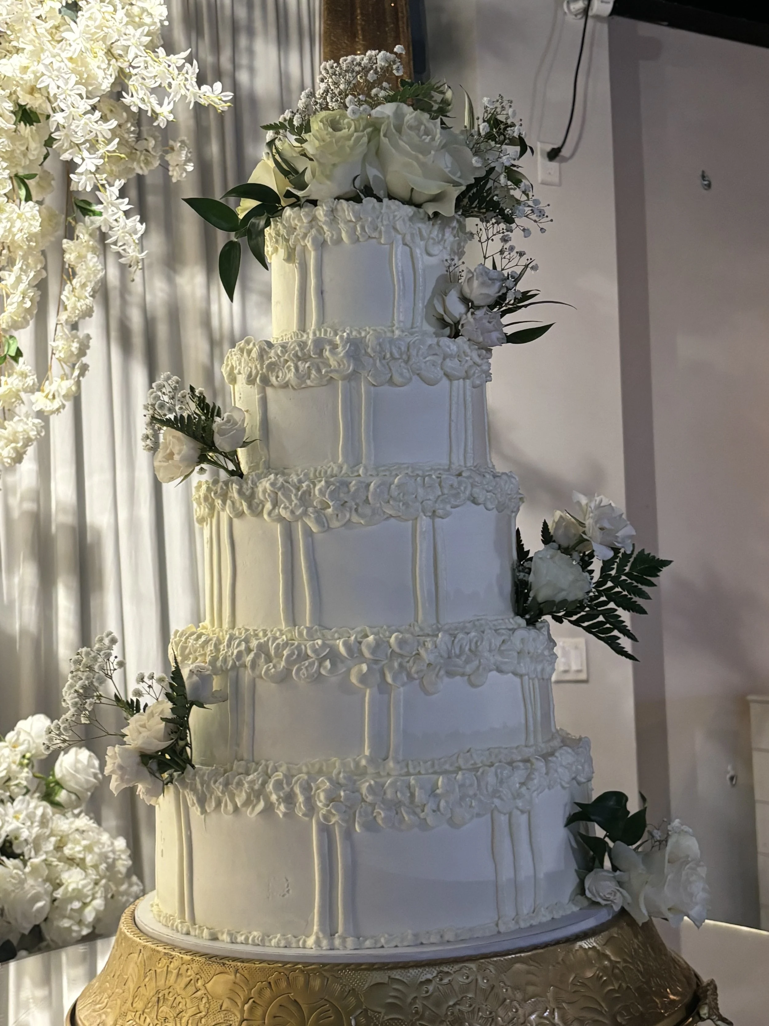 Large five tiered Atlanta Wedding cake for wedding at The Grand Ivy Point. Buttercream frosting, elegant design, fresh flowers