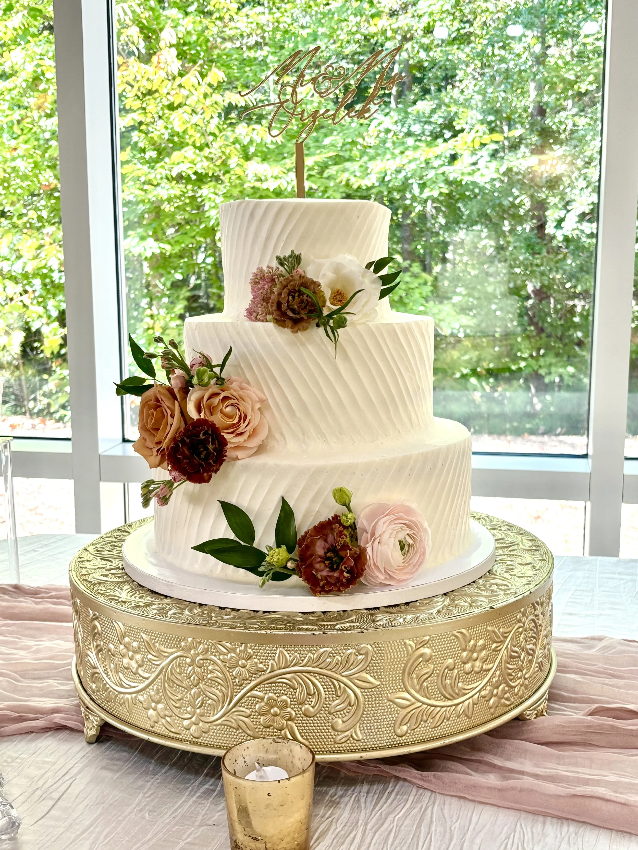 Three tiered textured buttercream wedding cake with fresh flowers.jpeg