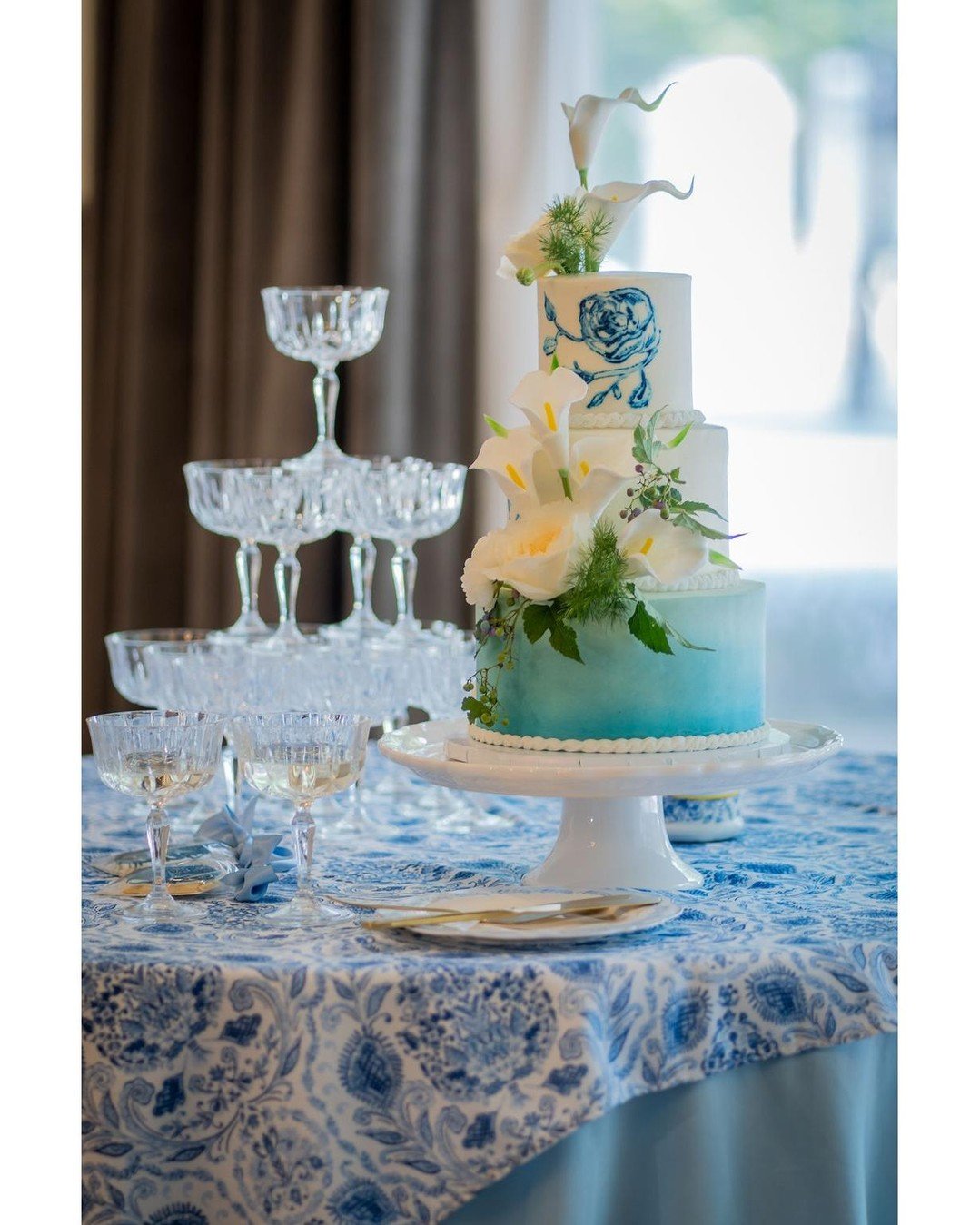 When a cake becomes a centerpiece ✨ This three-tier design balanced soft ombr&eacute; blue with hand-painted florals and draped fondant for a truly artful statement piece.
Planning, Design and Styling, Officiant- @forgetmeknotevents23 Planning, Desig