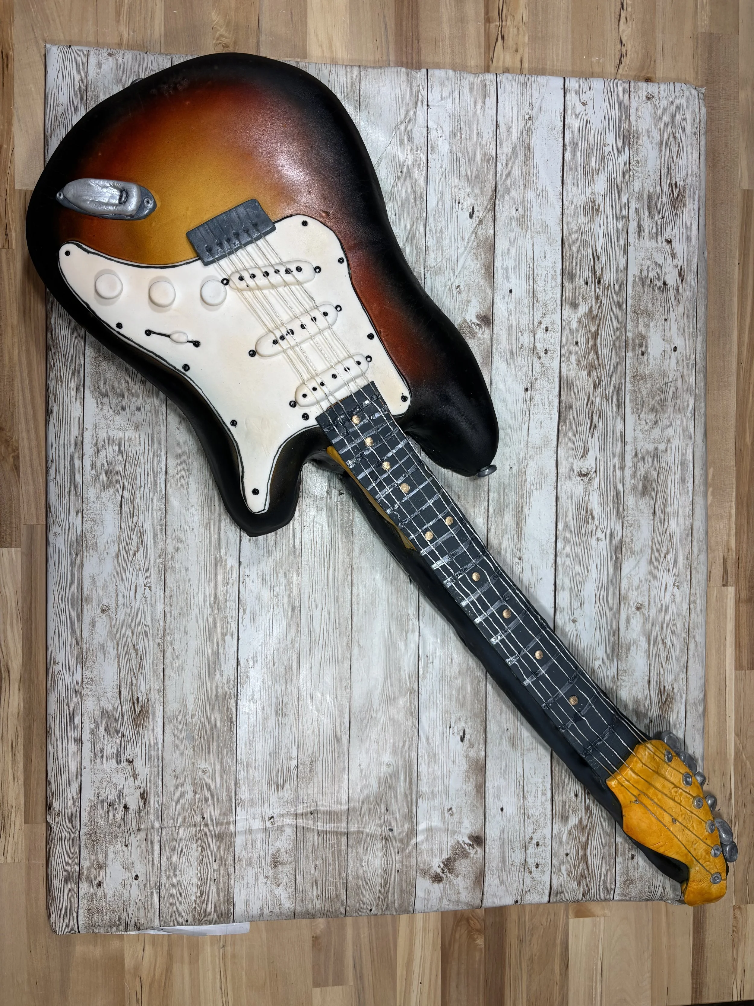 Realistic sunburst electric guitar cake by Artful Cakery by Julie, designed for music-themed celebrations in Atlanta and North Georgia.