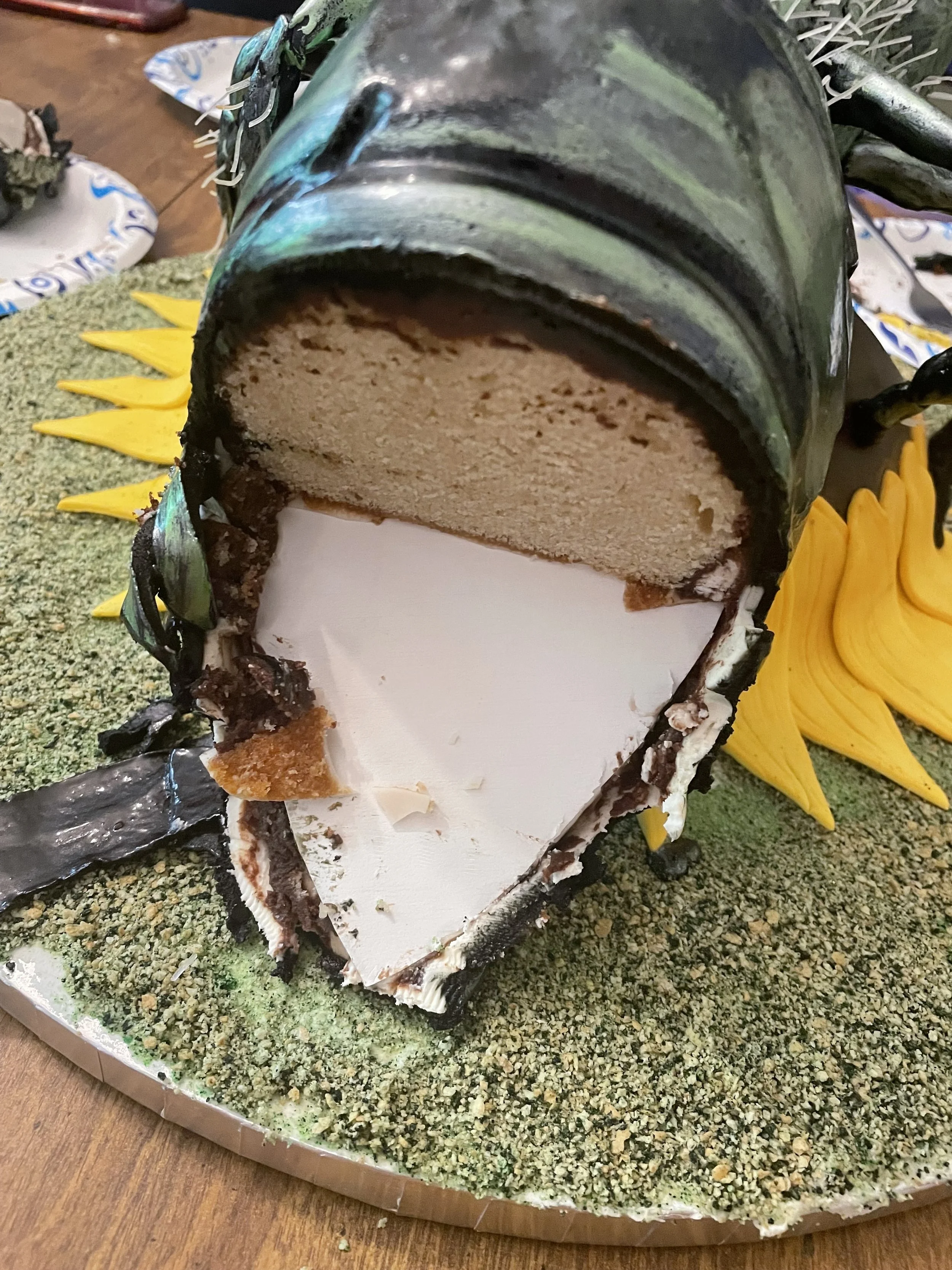 A cake designed to look like a green metallic sweat bee, with a realistic pattern on the outside and with layers of cake and cream.