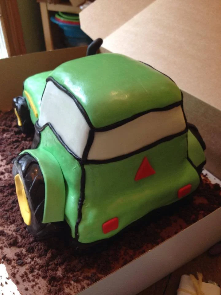 Carved green tractor cake for farm themed celebration
