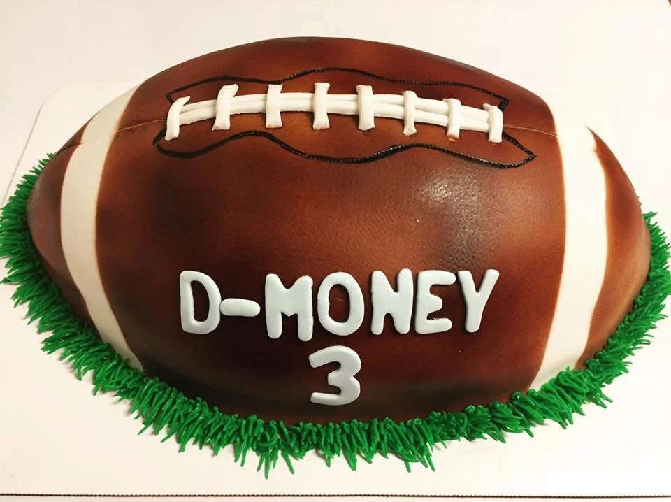 Carved half football cake with realistic stitching and textured surface