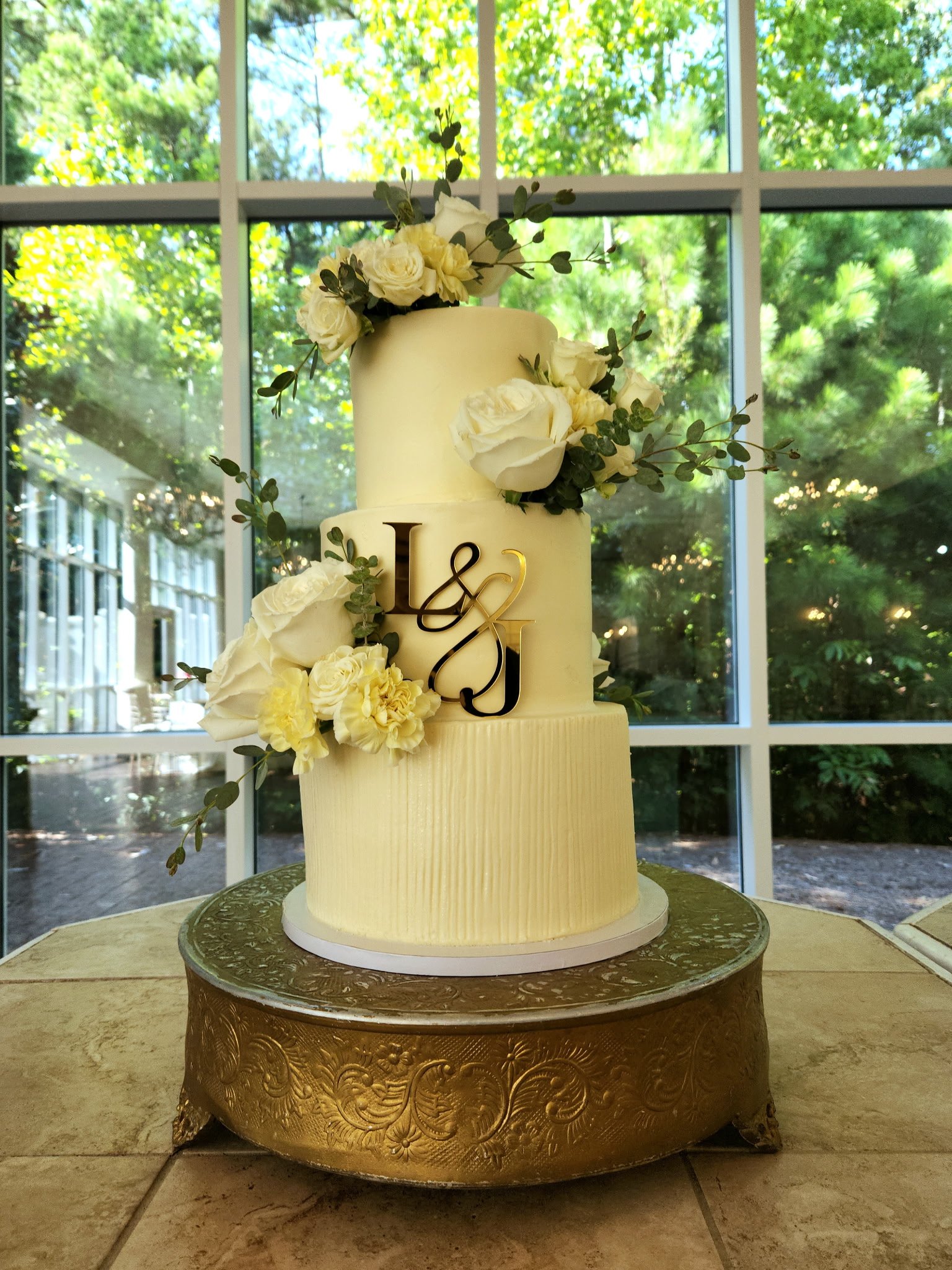 Simple buttercream cake with textured bottom tier, initials cake charm, and fresh florals at Ashton Gardens Atlanta, Georgia