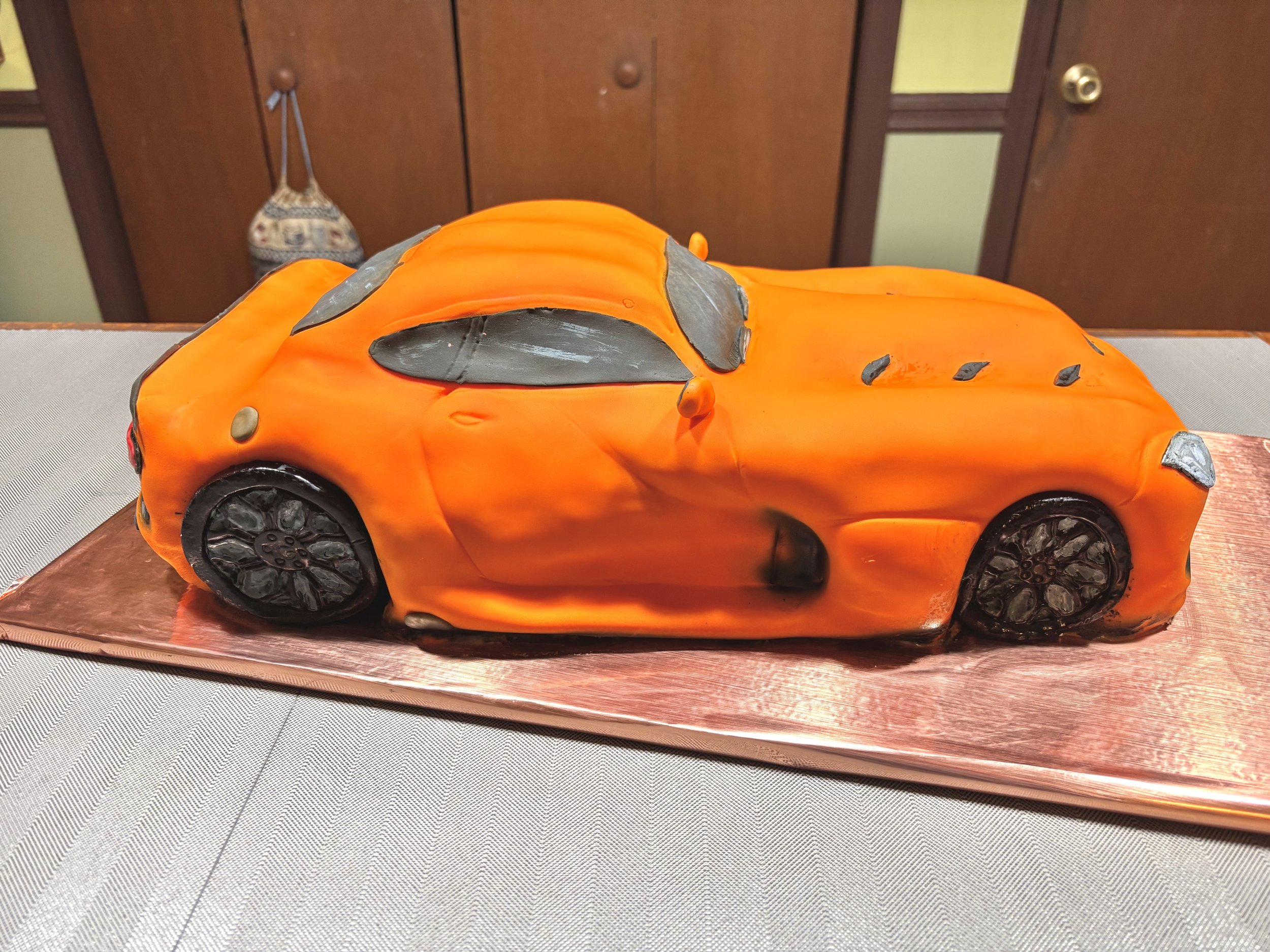 Orange Dodge Viper sports car cake sculpted with realistic automotive details.