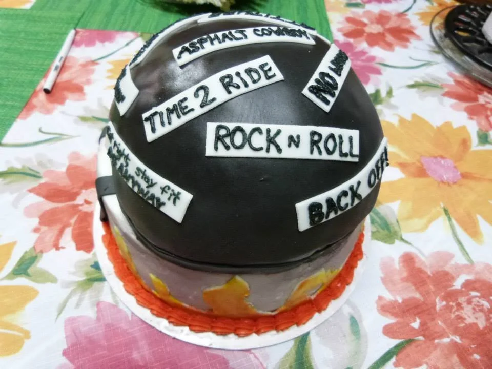 Sculpted motorcycle helmet cake with custom decals and sayings