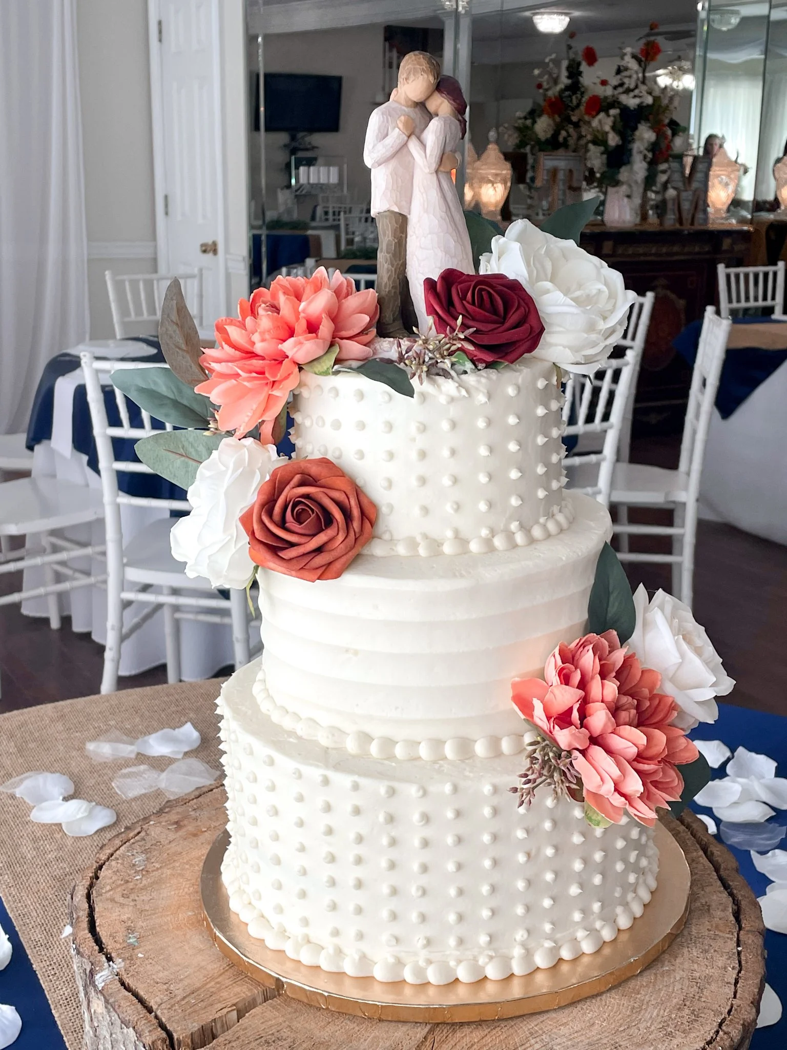 Atlanta Wedding Cakes Red Velvet and vanilla three tiered wedding cake with textured frosting and dots with artificial flowers