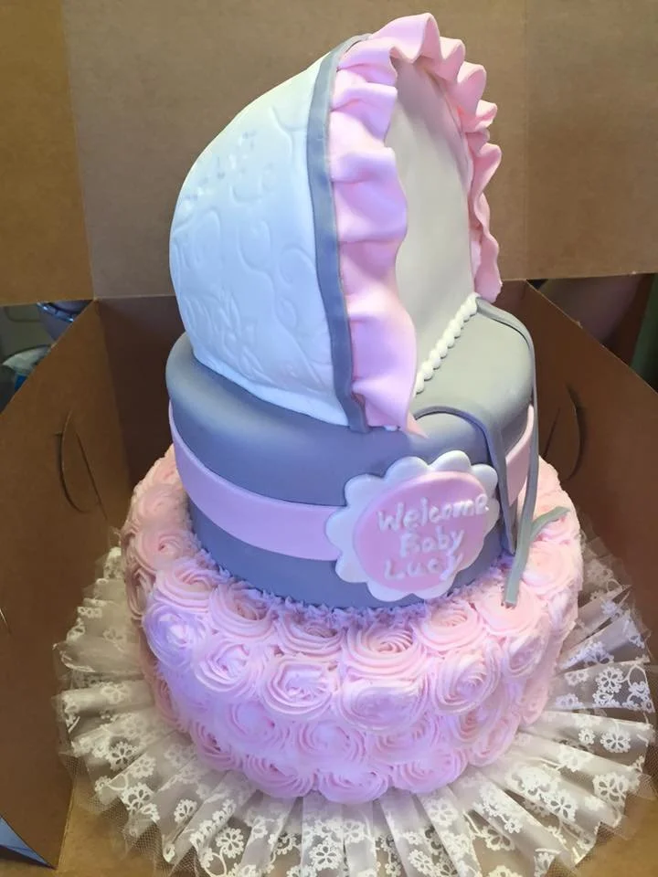 Sculpted baby bonnet cake with soft pastel fondant detailing