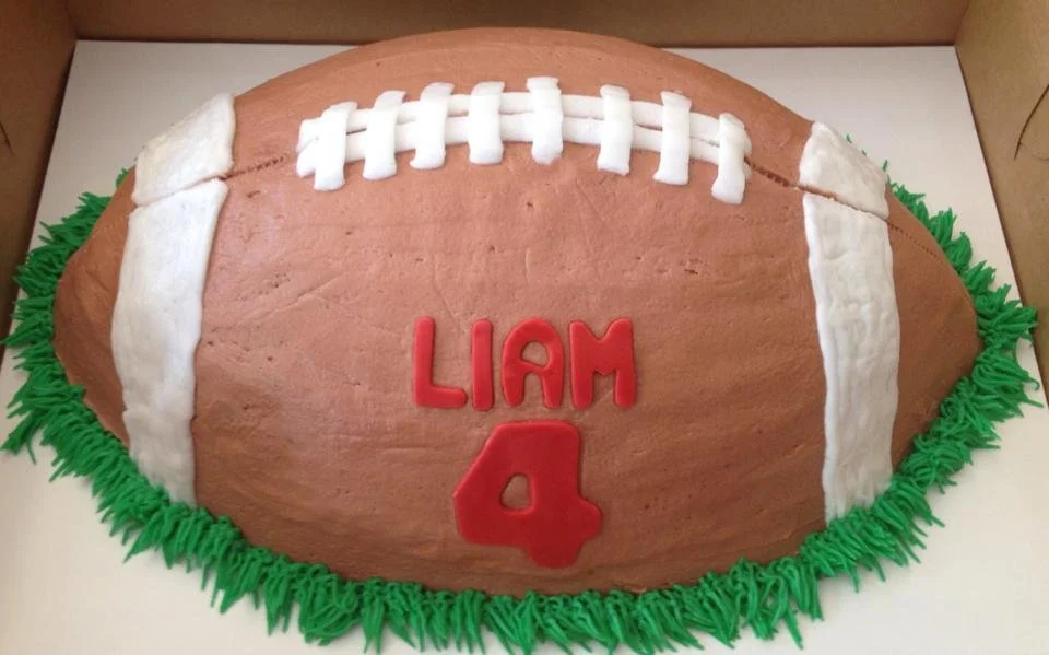 Realistic carved half football cake with textured surface and stitching