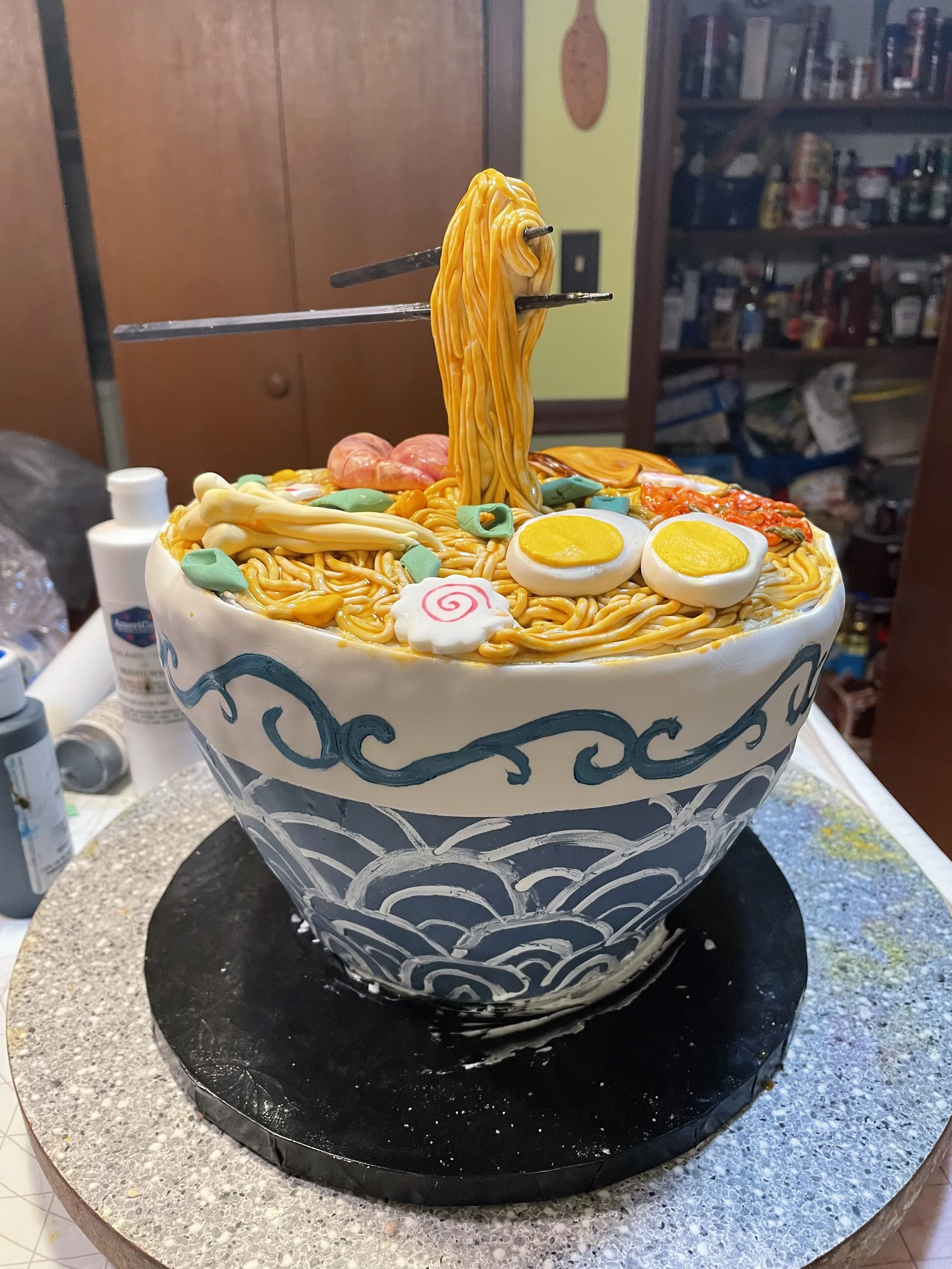 Cake decorated to look like a bowl of ramen with noodles, eggs, and other toppings.