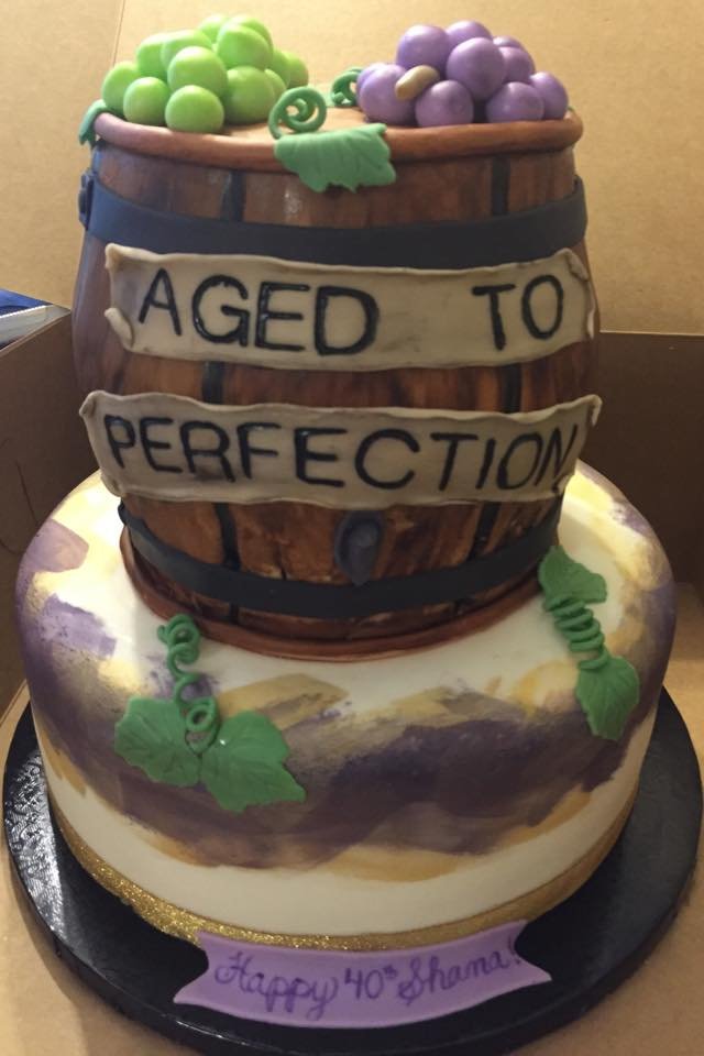 Rustic wine barrel cake with grapes and 'aged to perfection' design