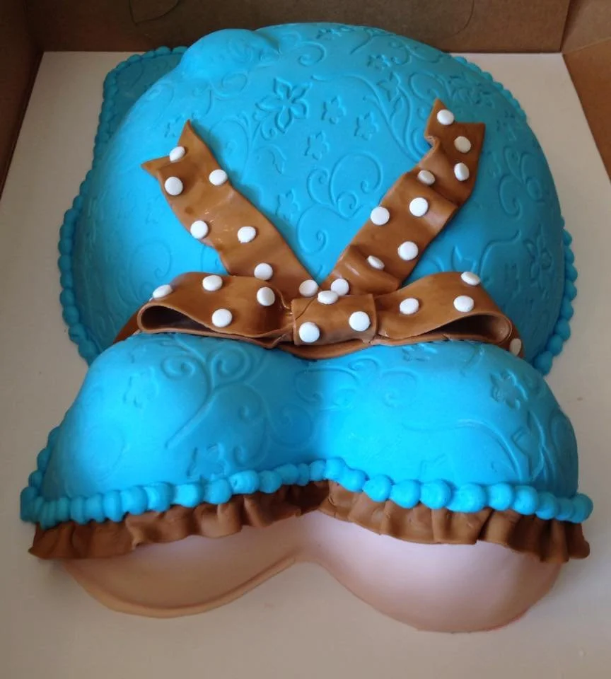 Blue sculpted pregnant torso cake with brown polka dot bow for baby shower