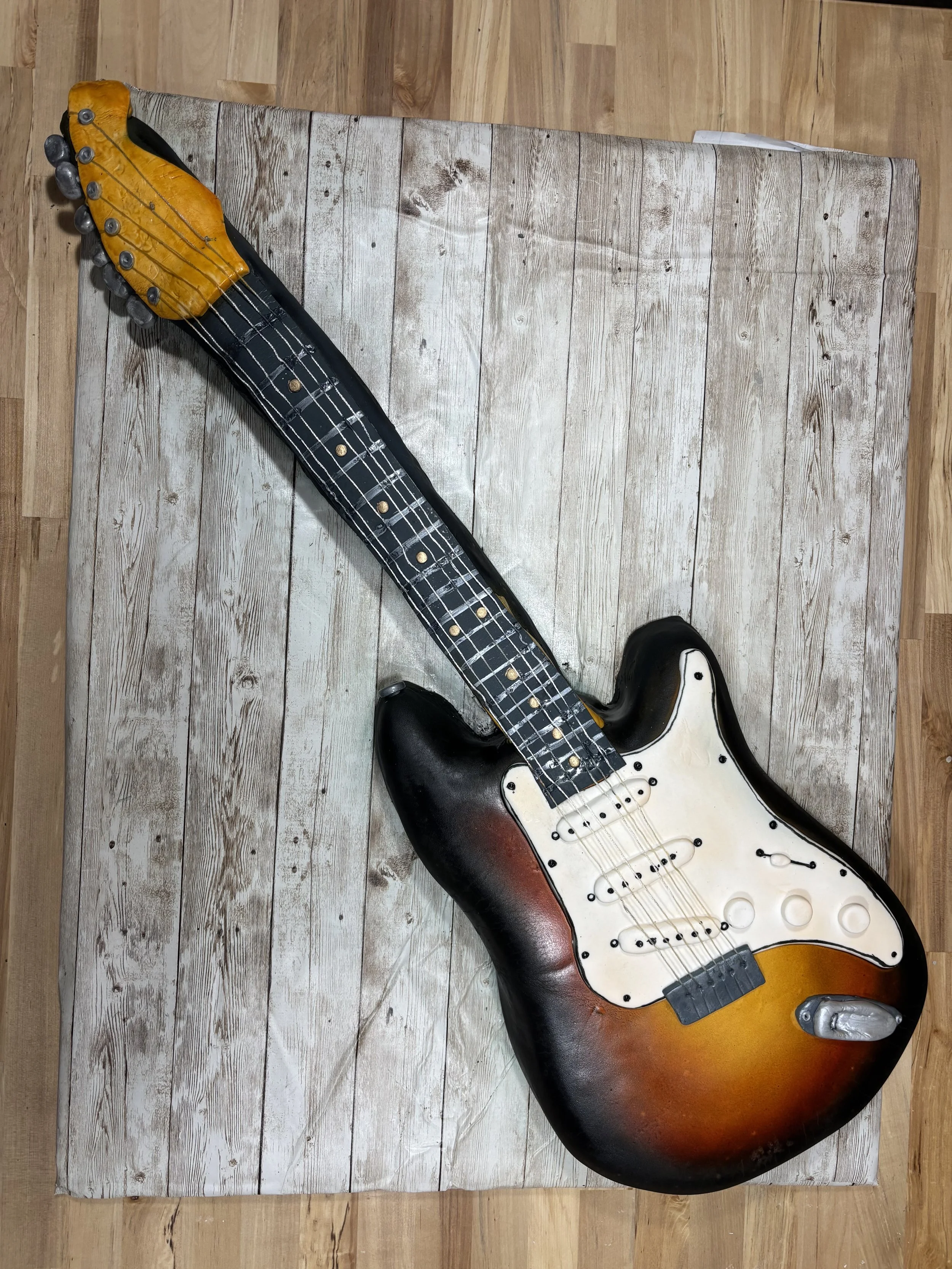 Sunburst electric guitar cake designed to resemble a classic electric guitar.