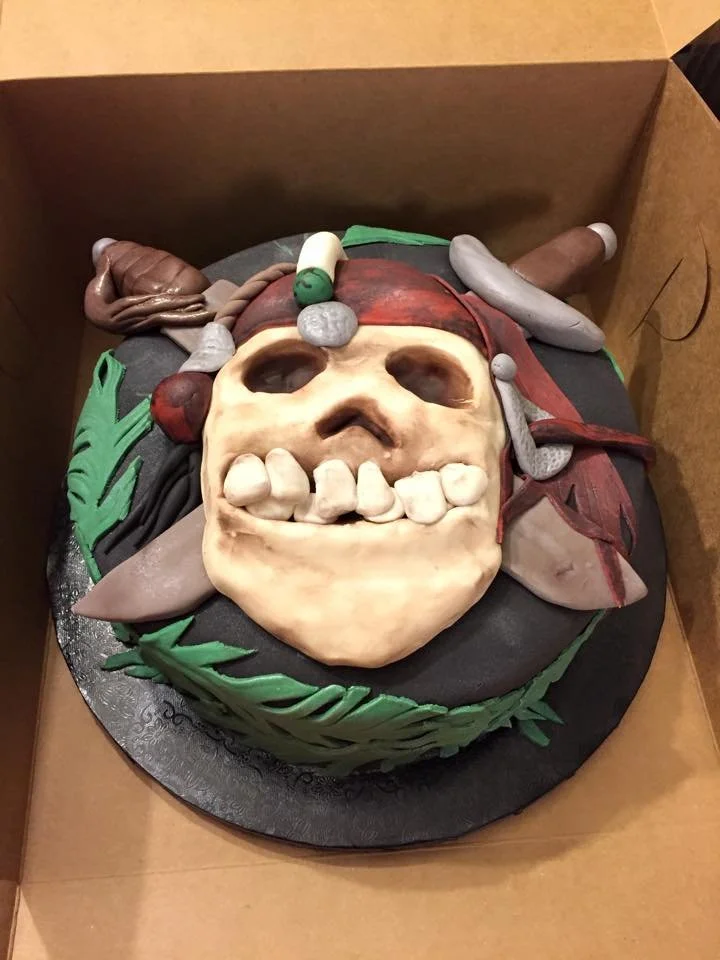 Sculpted pirate skull and crossbones cake for themed celebration