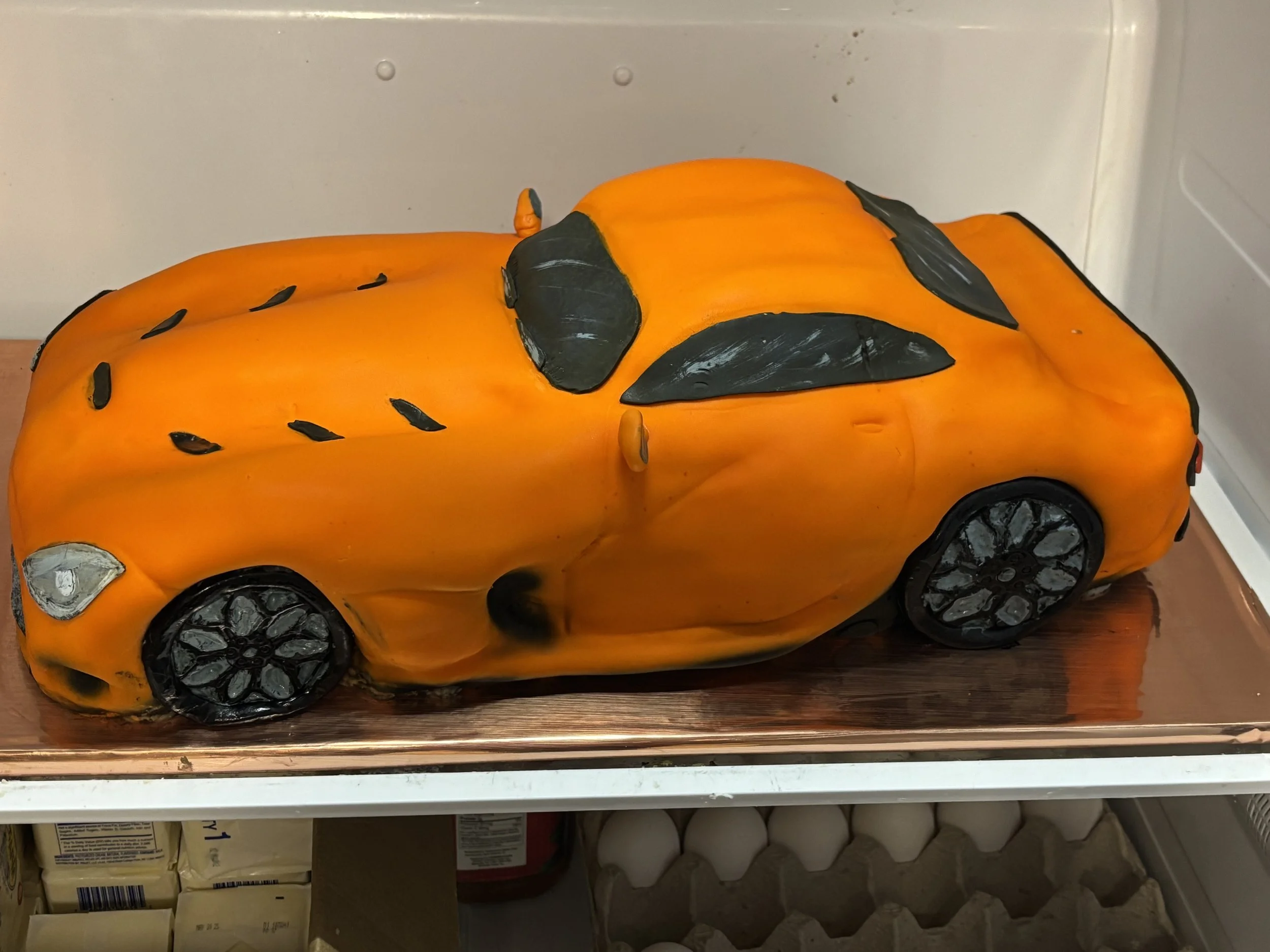 Orange Dodge Viper sports car cake sculpted with realistic automotive details.