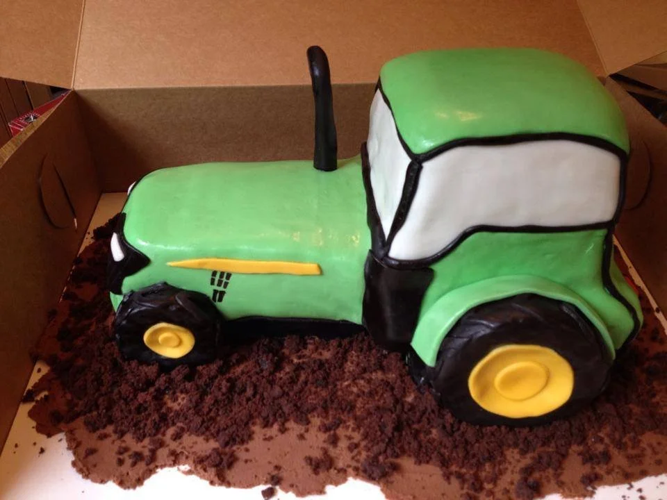 Carved green tractor cake for farm themed celebration