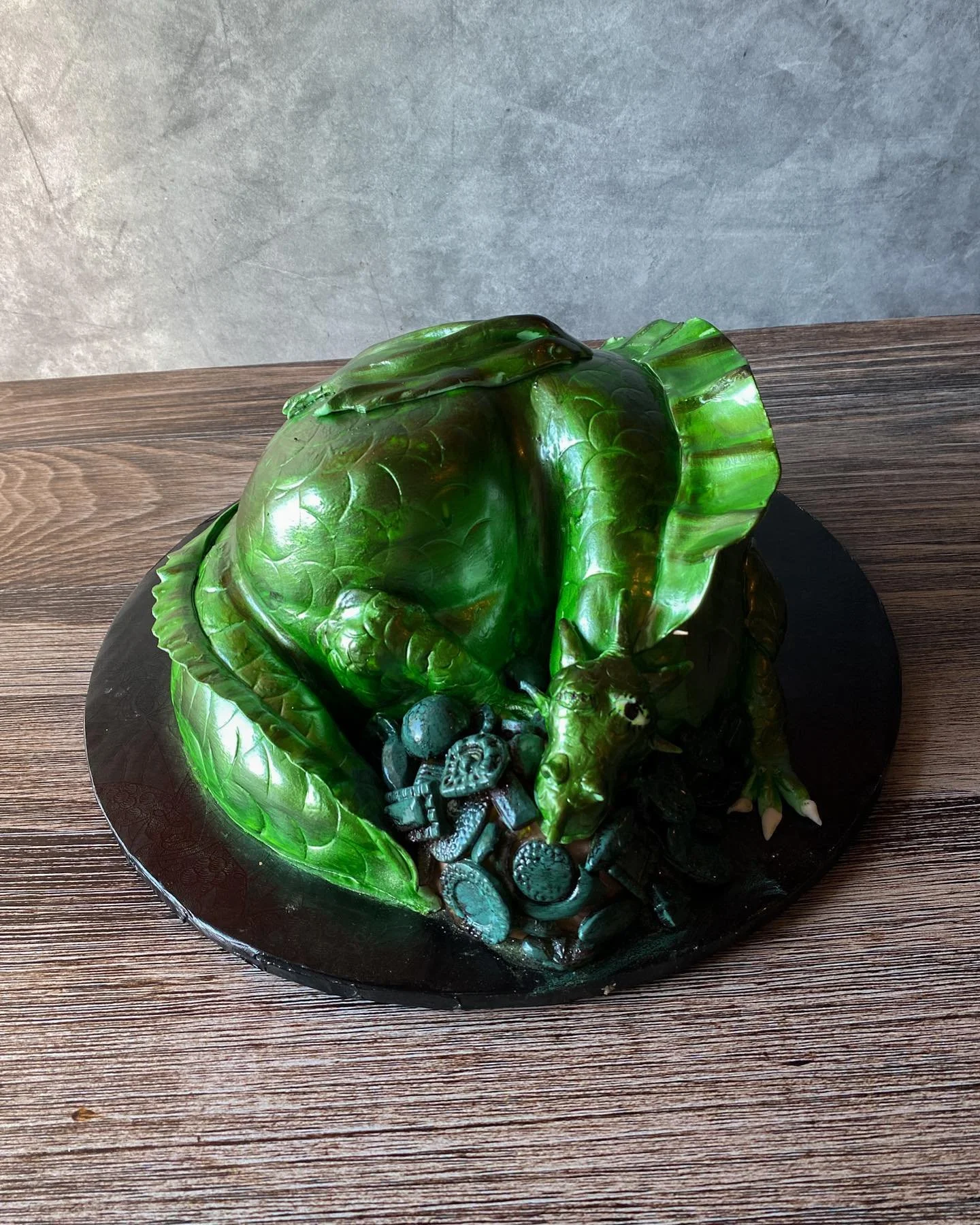 Detailed green fantasy dragon sculpted cake with textured scales