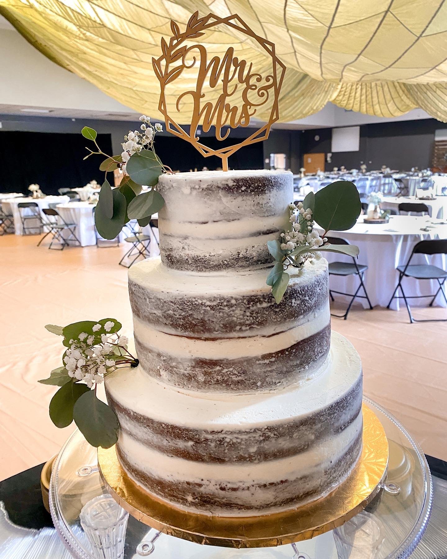 Naked iced wedding cake, chocolate with buttercream frosting, eucalyptus, baby's breath, rustic wedding cake, 3 tiered wedding cake Artful Cakery by Julie Flowery Branch, GA  
