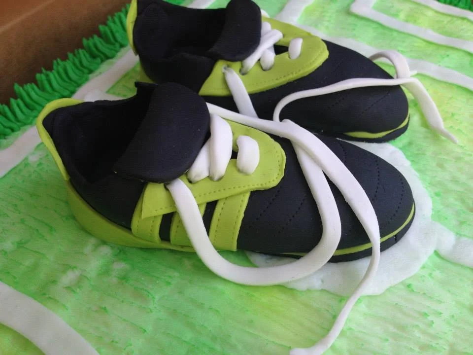 Realistic sculpted soccer cleat cake with detailed laces and studs