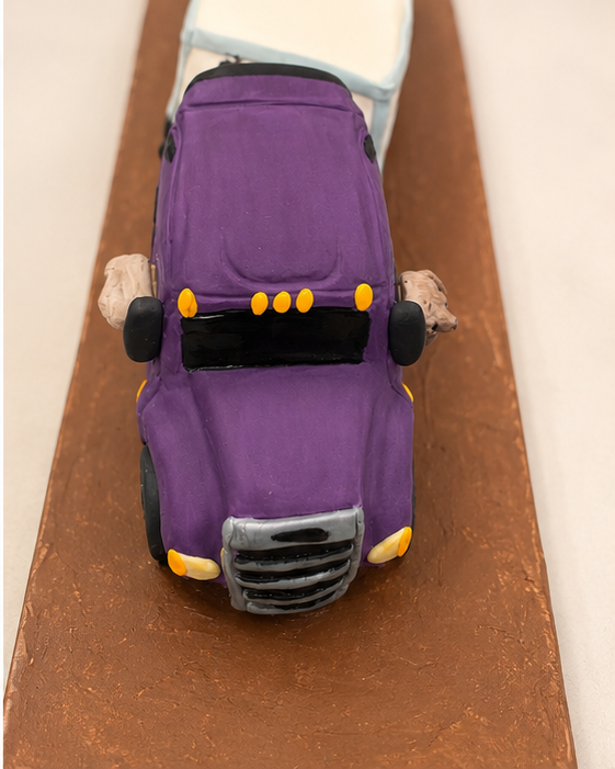 Every angle tells the story. From the sculpted hood and chrome-style grille to the custom purple cab and tiny co-pilot, this semi truck cake was designed to resemble the birthday recipient's own truck.