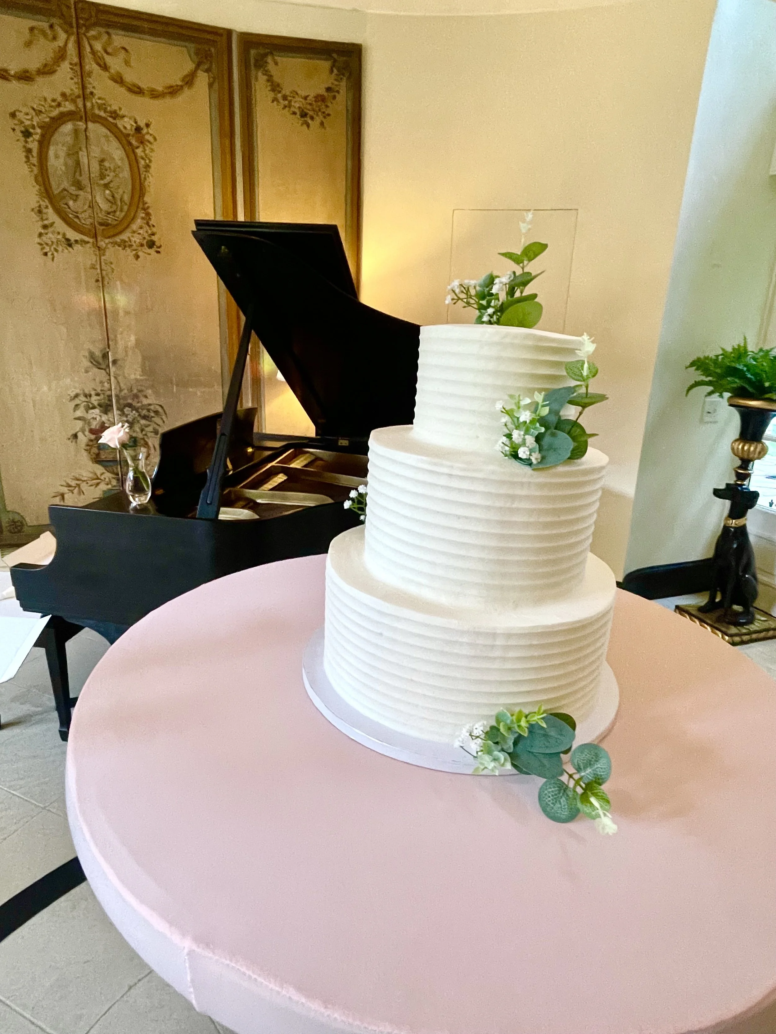 Three tiered spatula iced wedding cake with flowers.jpeg