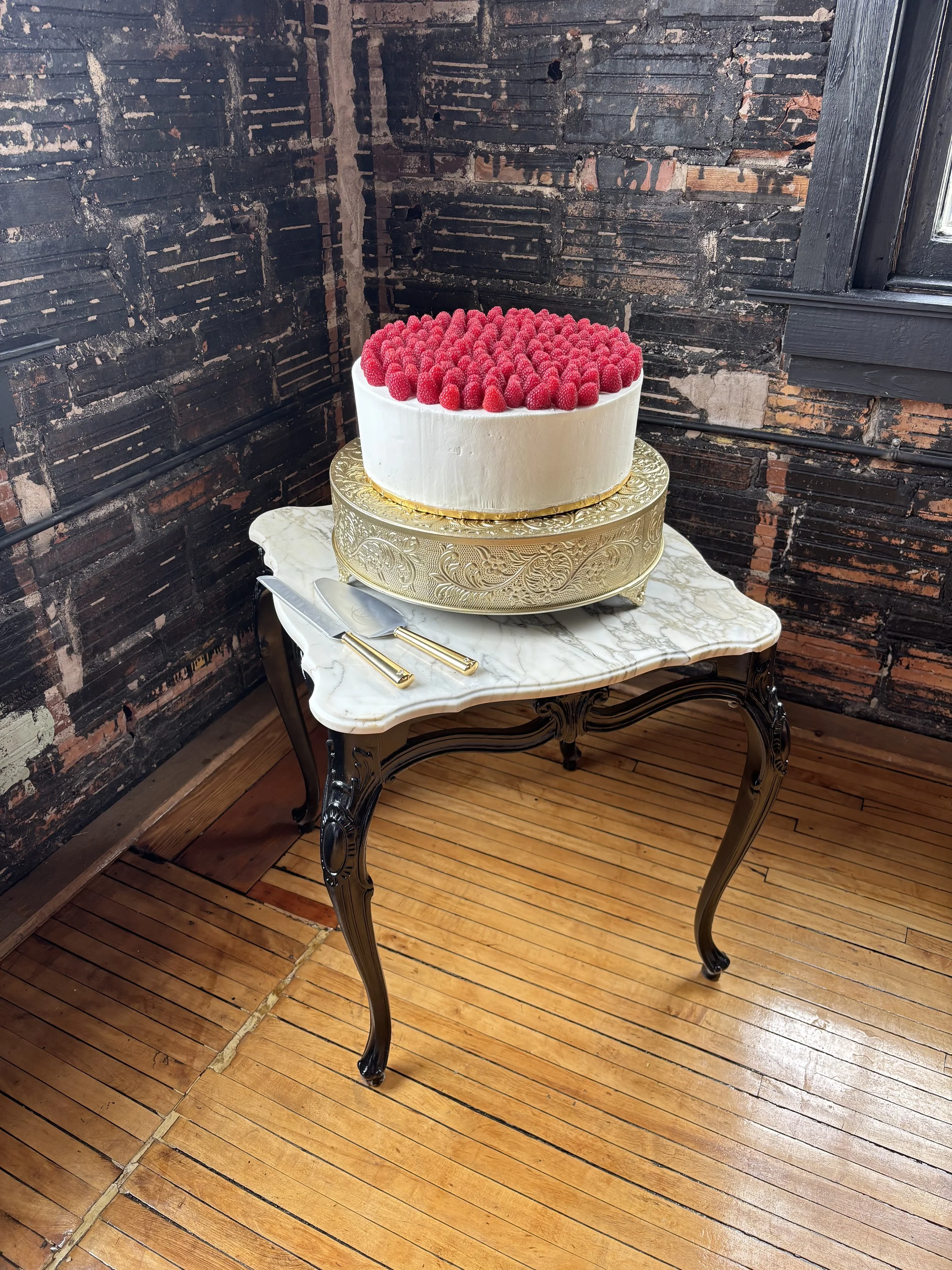 Single tier large wedding cake, classic Italian style cake, covered in raspberries, at New Holland Parlor in Gainesville, Georgia