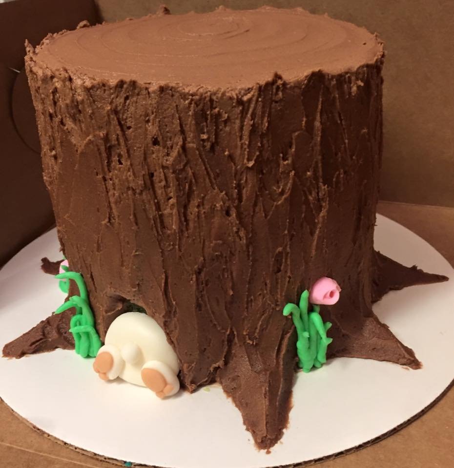 Easter themed tree stump cake with bunny tail and feet sticking out