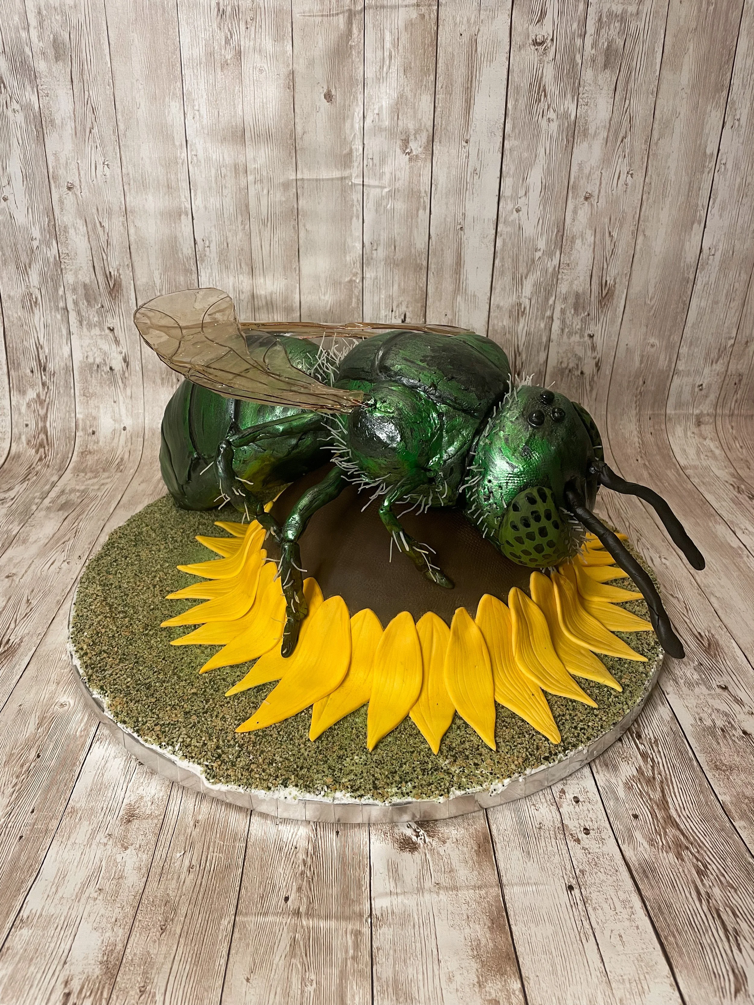 Realistic metallic green sweat bee cake with detailed wings and body.