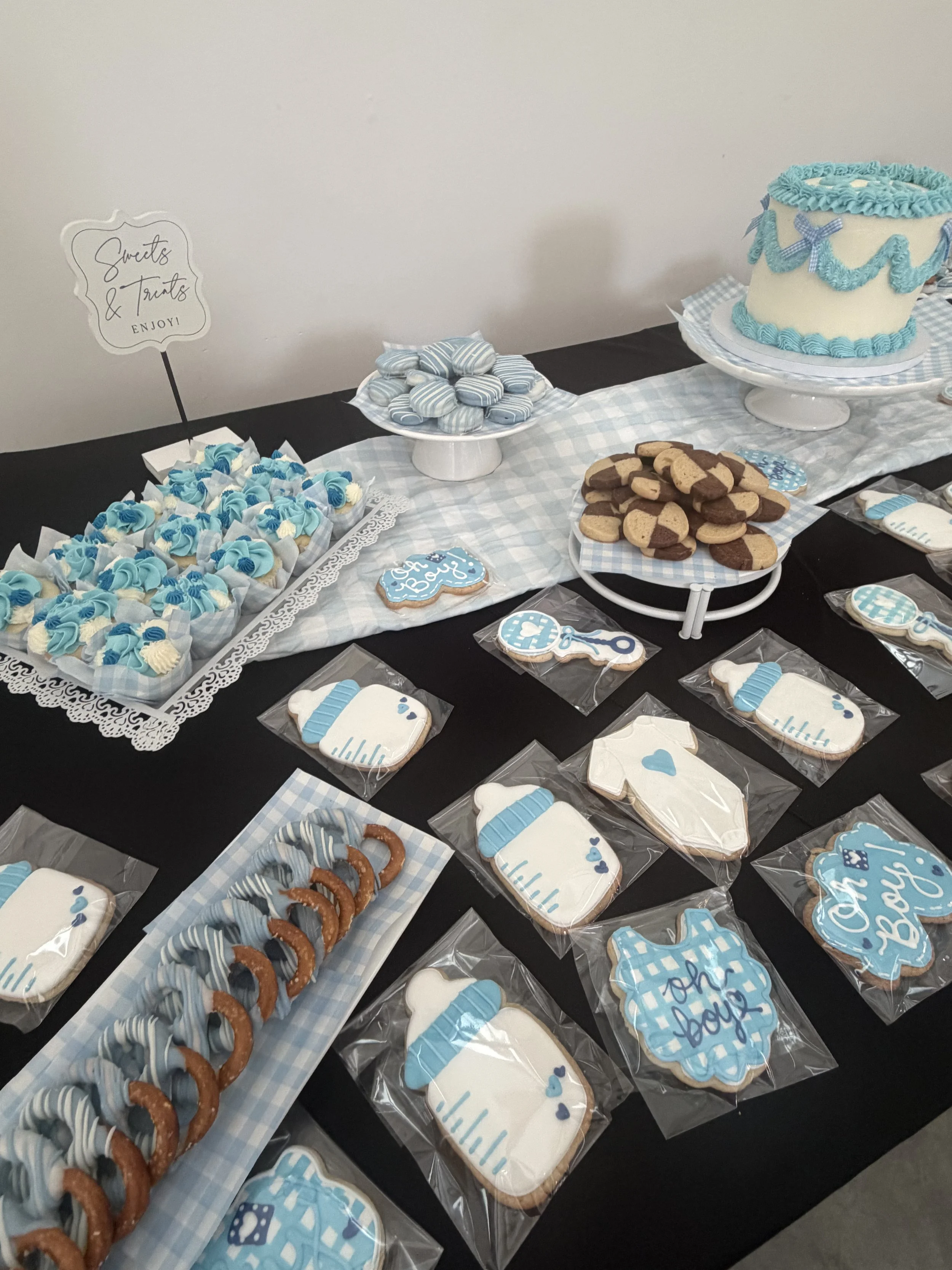 Cupcakes, dipped pretzels, decorated cookies, dipped Oreos, centerpiece cake, and checkerboard cookies