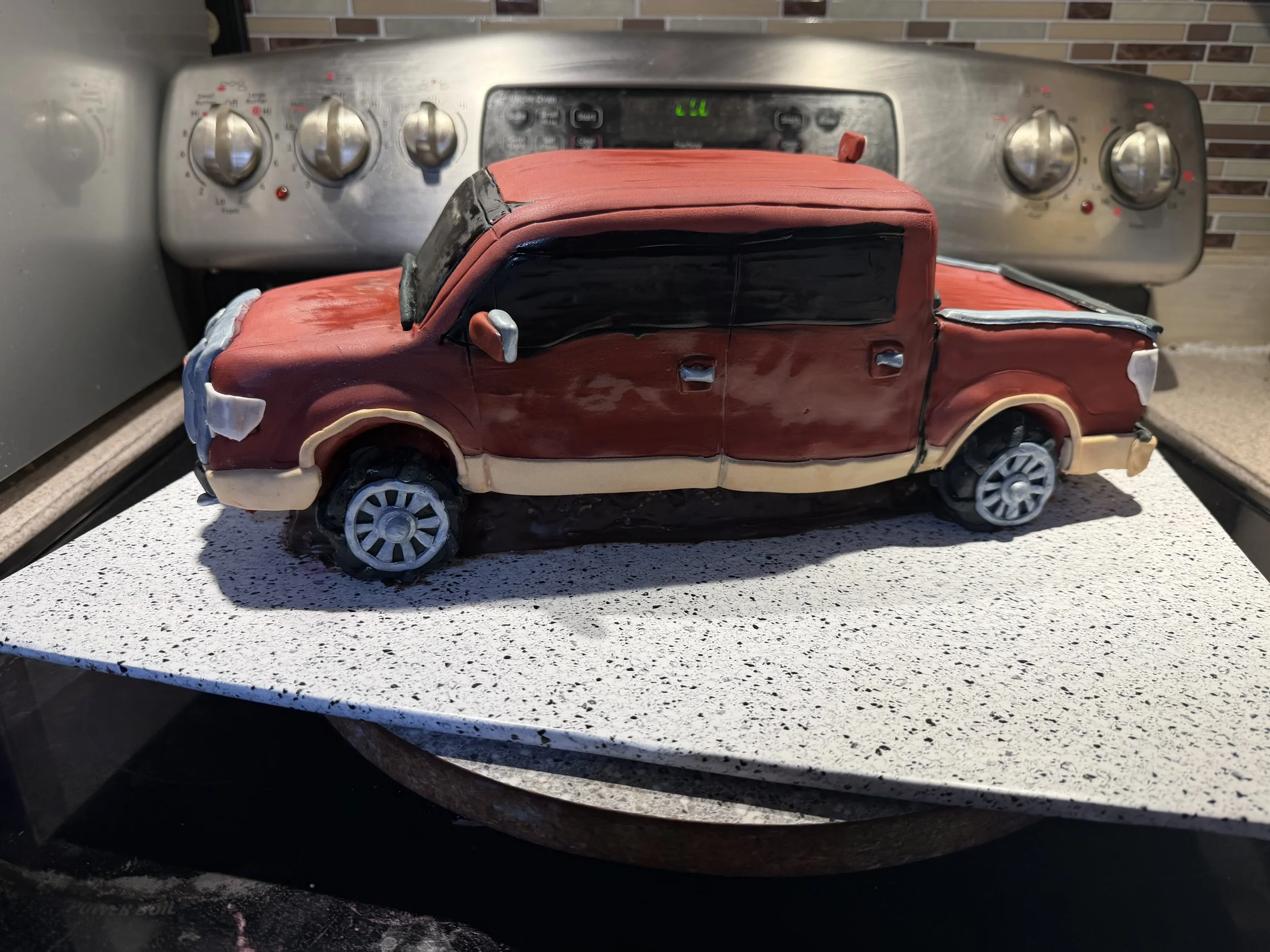 This side profile highlights the truck's realistic proportions, four-door cab, custom wheels, and handcrafted edible details that make it a unique birthday centerpiece.