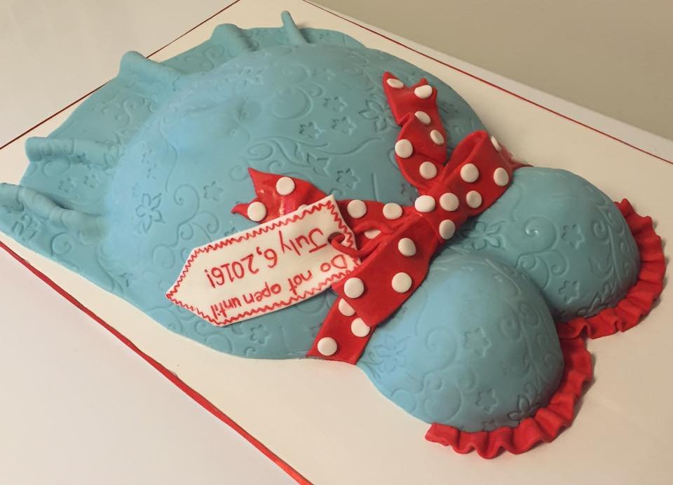Turquoise pregnant torso cake with red polka dot bow for baby shower