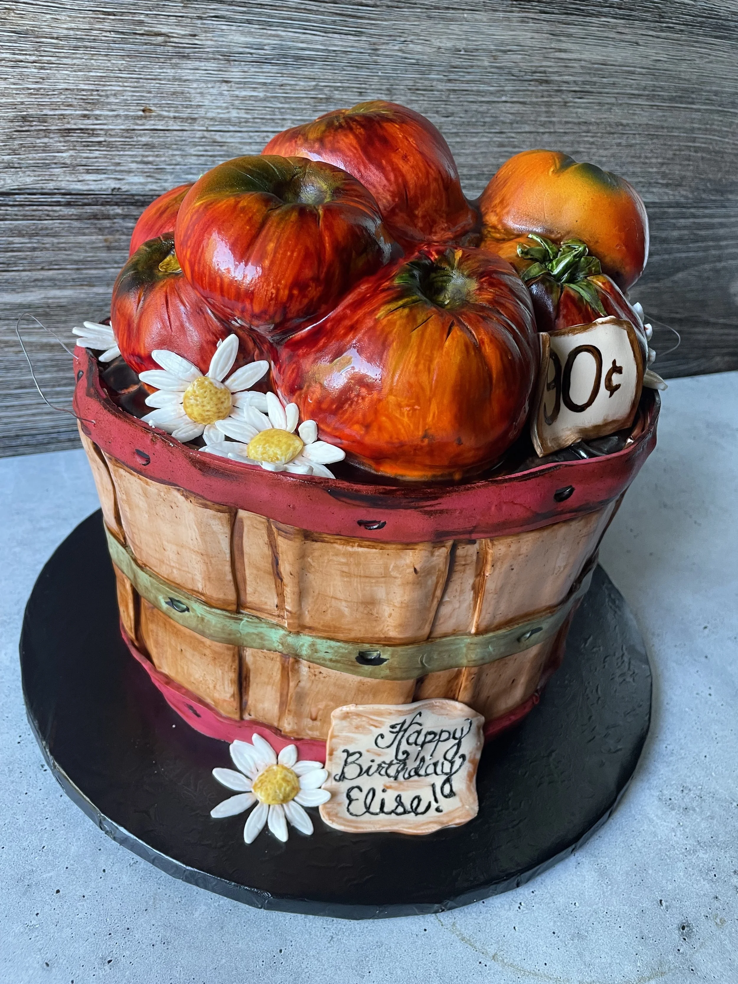 Realistic tomato basket cake designed to resemble fresh garden tomatoes in a rustic basket.