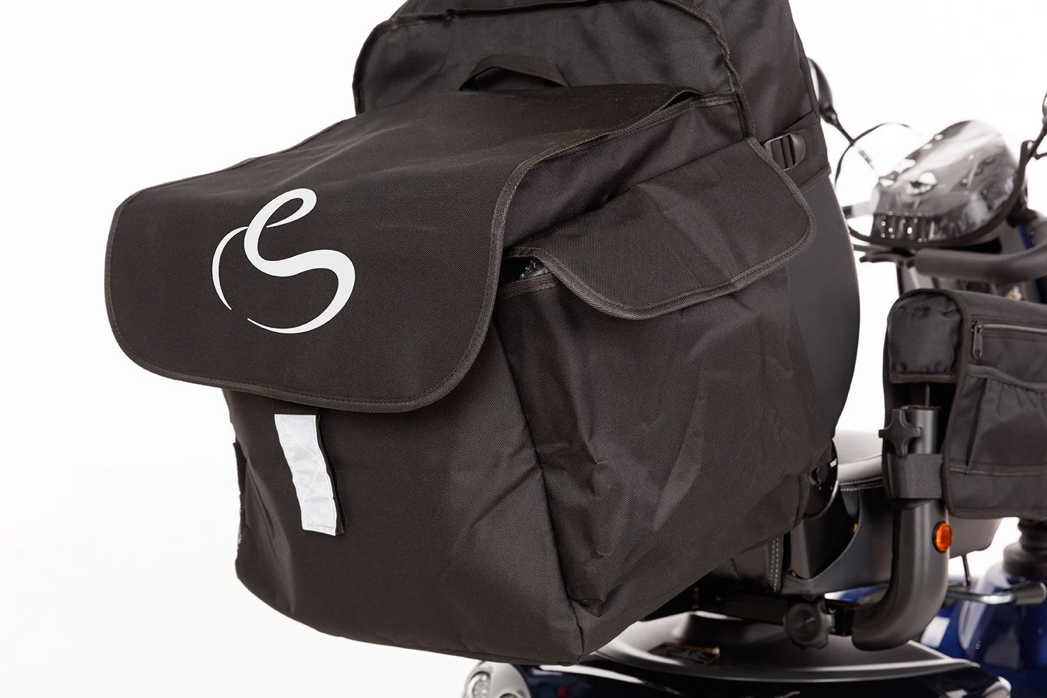 Close-up of a mobility scooter with a large backpack bag attached to the seat.