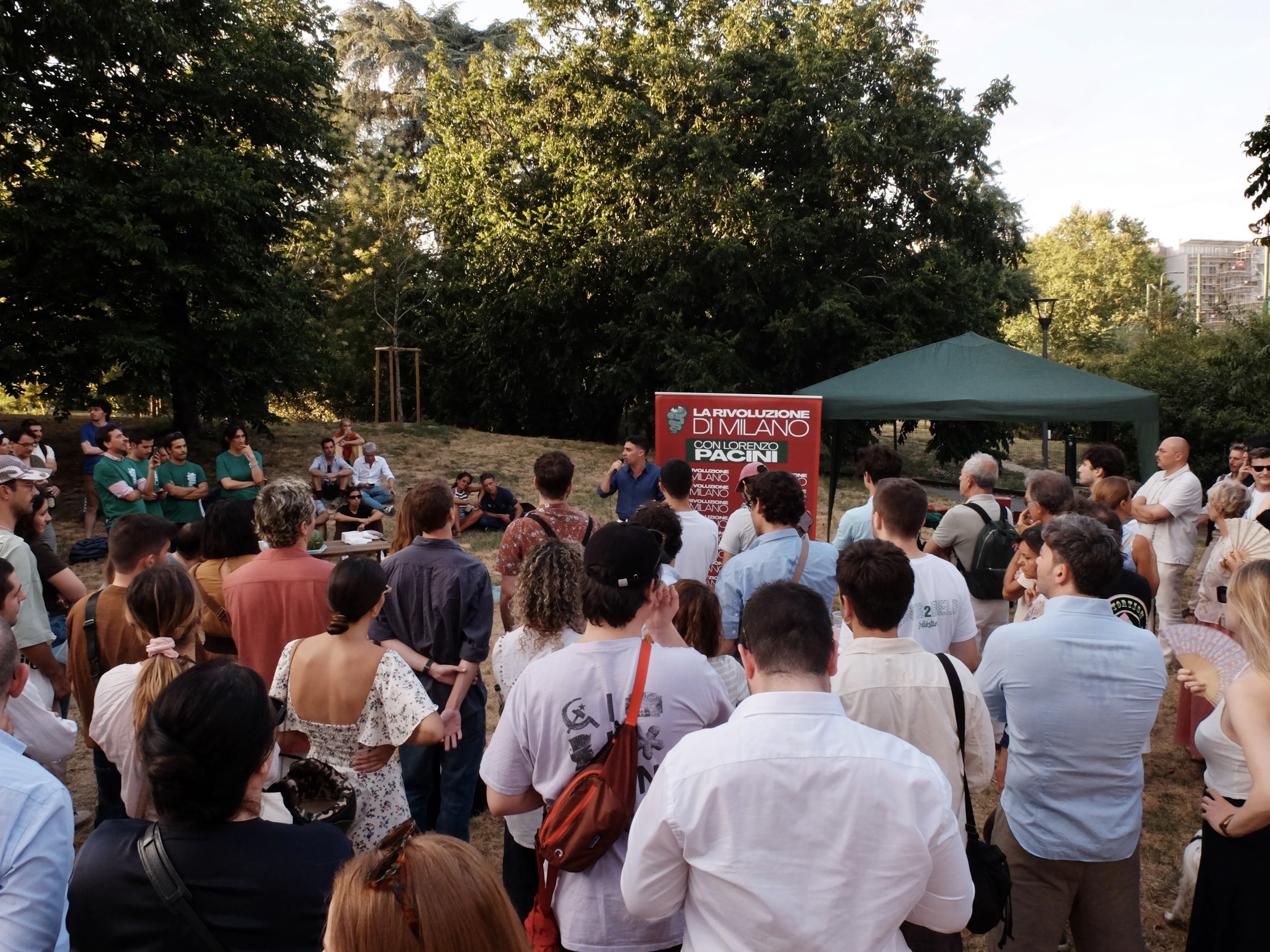 Cittadine e cittadini milanesi assistono a un discorso di Lorenzo Pacini, candidato sindaco a Milano