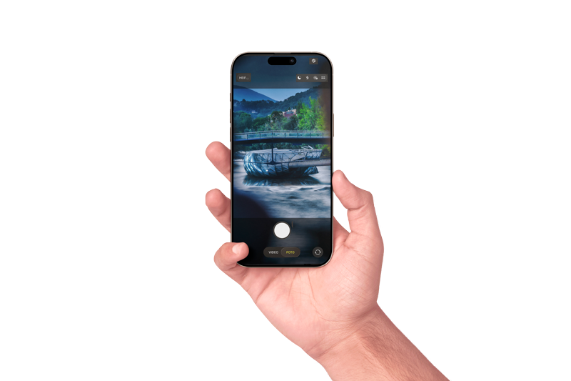 Eine Hand hält ein Smartphone und macht ein Foto von einem Fluss mit einem Boot und einem Brücke im Hintergrund.