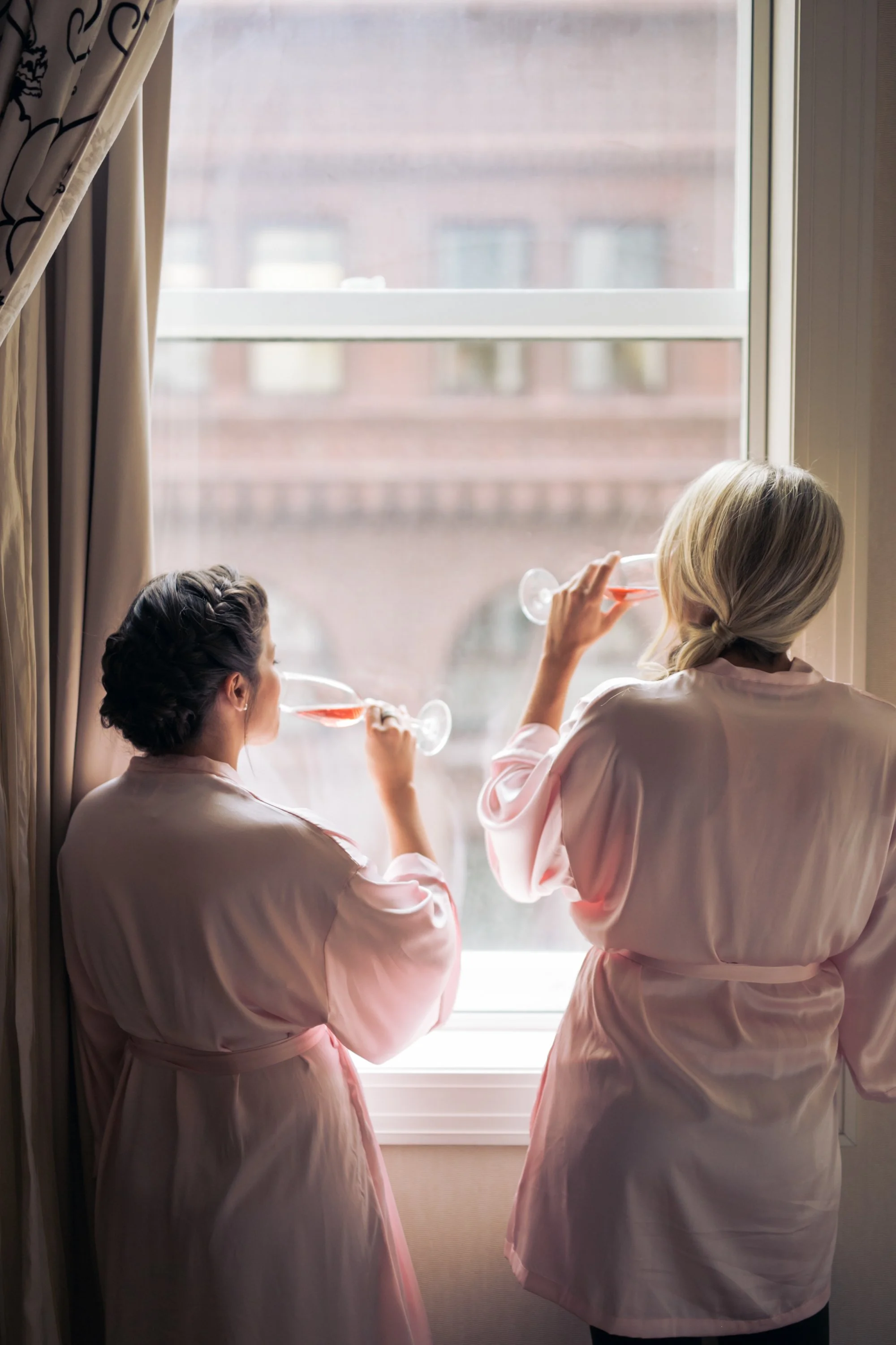 bridemaids window drinking champagne Chicago wedding photographer near me