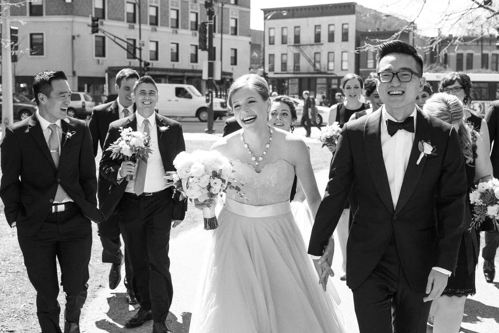 bride and groom laughing walking with bridal party wedding photography