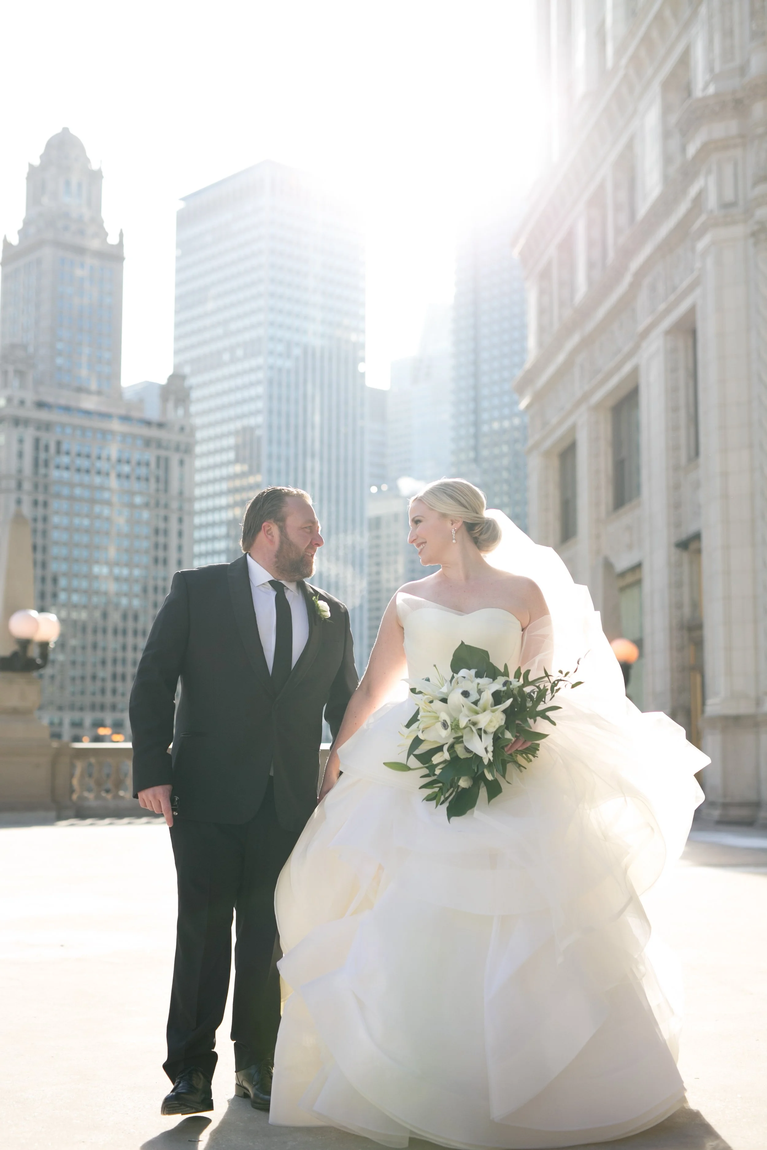bride with groom walking holding hands Chicago downtown Wrigley Building wedding photography packages