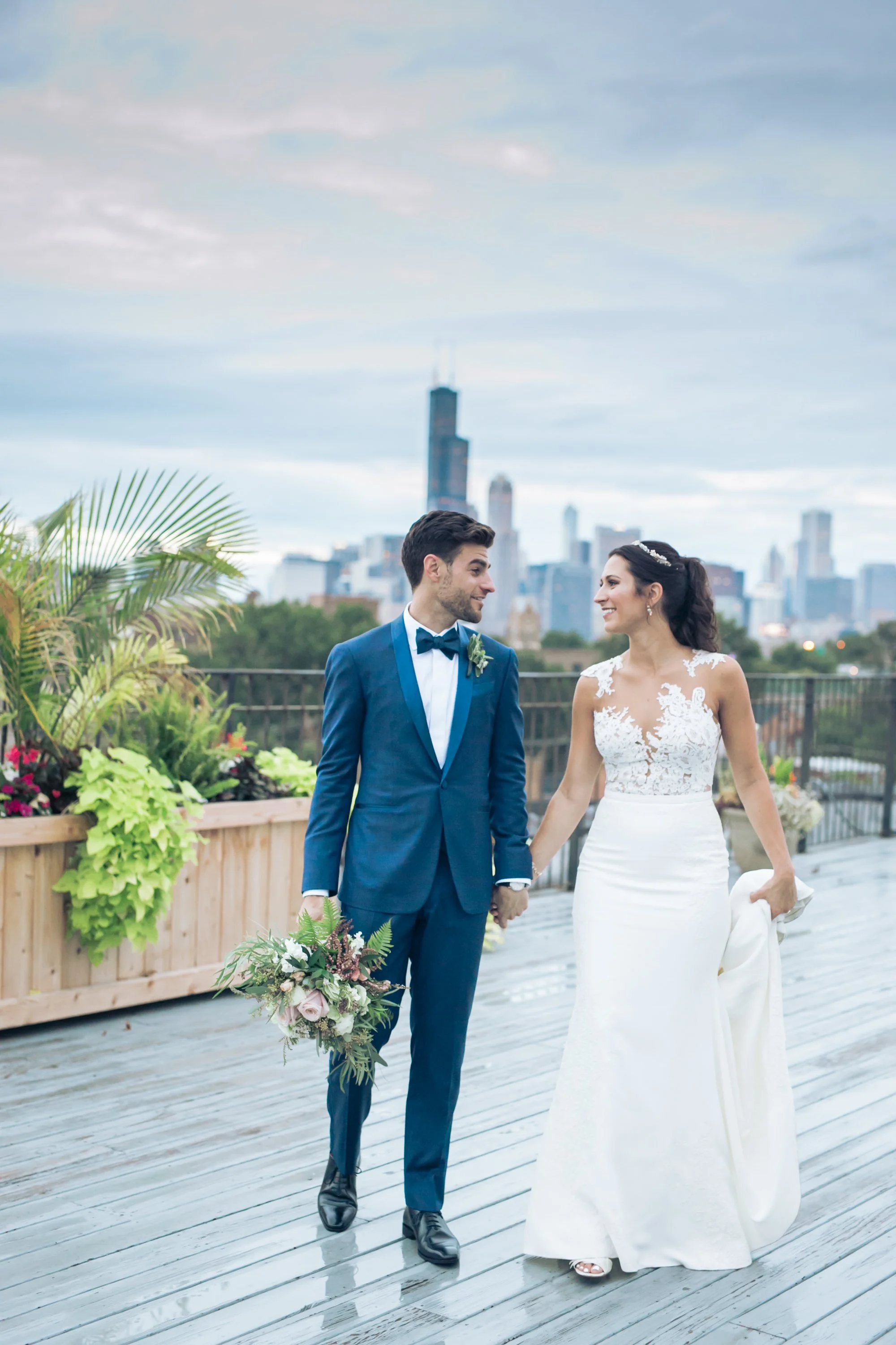 bride and groom walking on rooftop Chicago skyline wedding photographer near me 