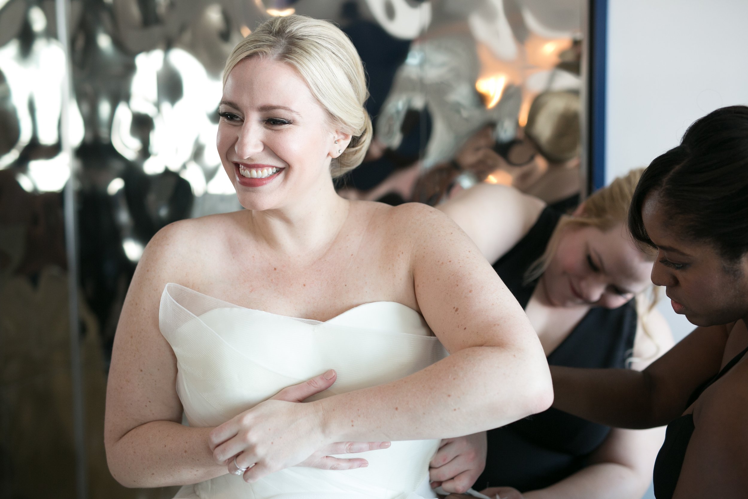 bride getting dressed smiling average price for wedding photographer