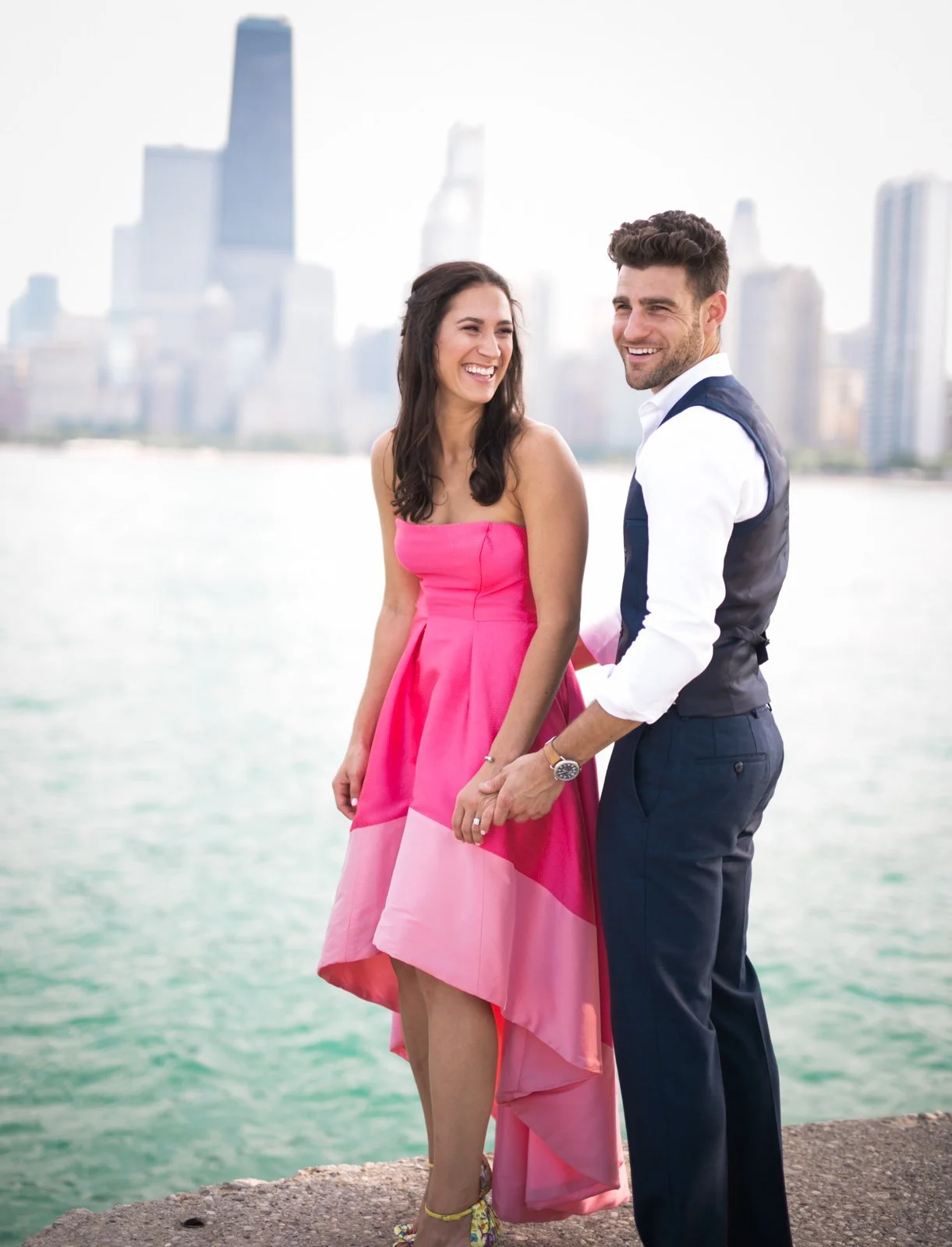 Couple standing near water Chicago skyline engagement photo session
