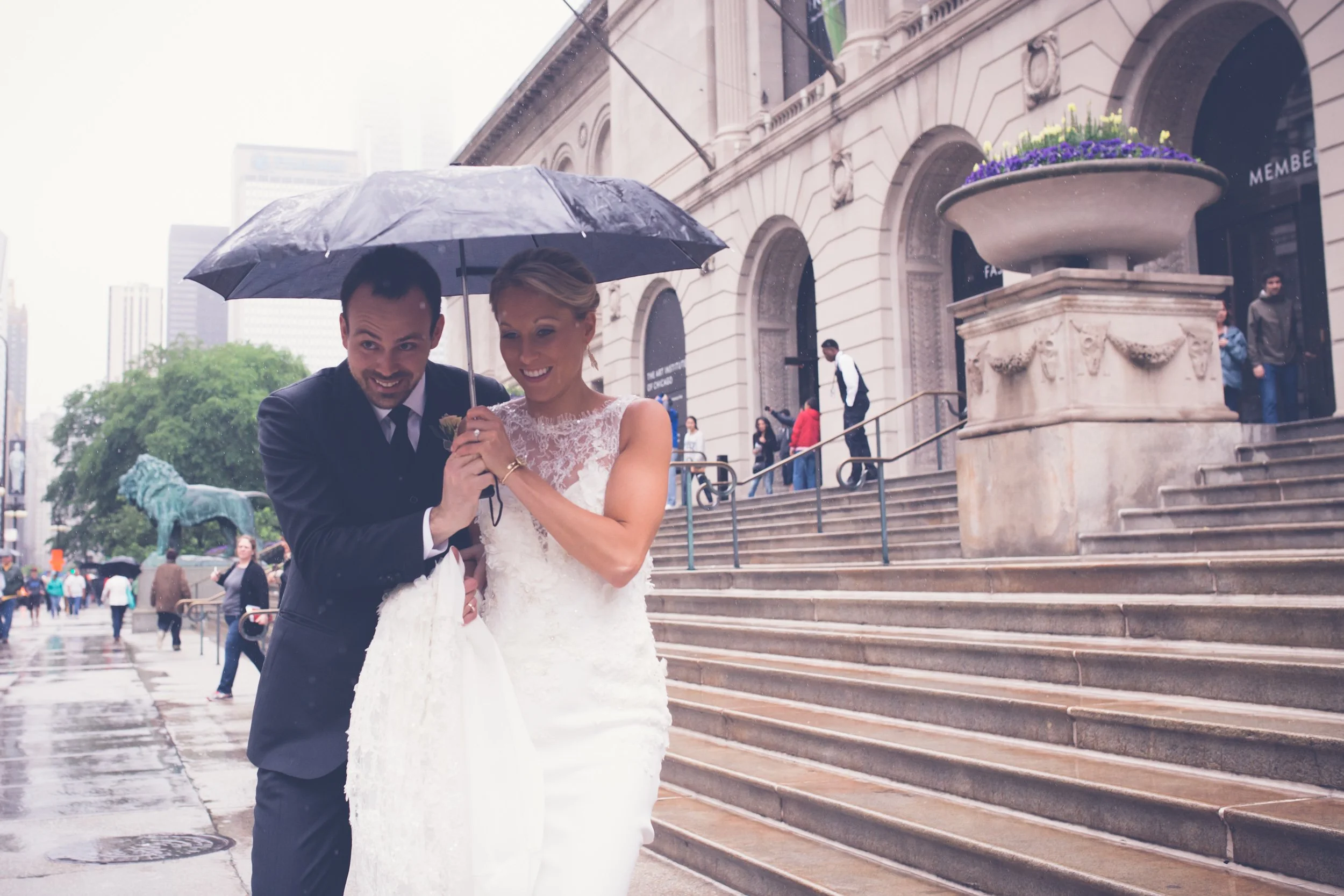 bride and groom running in the rain chicago art institute Chicago wedding photography