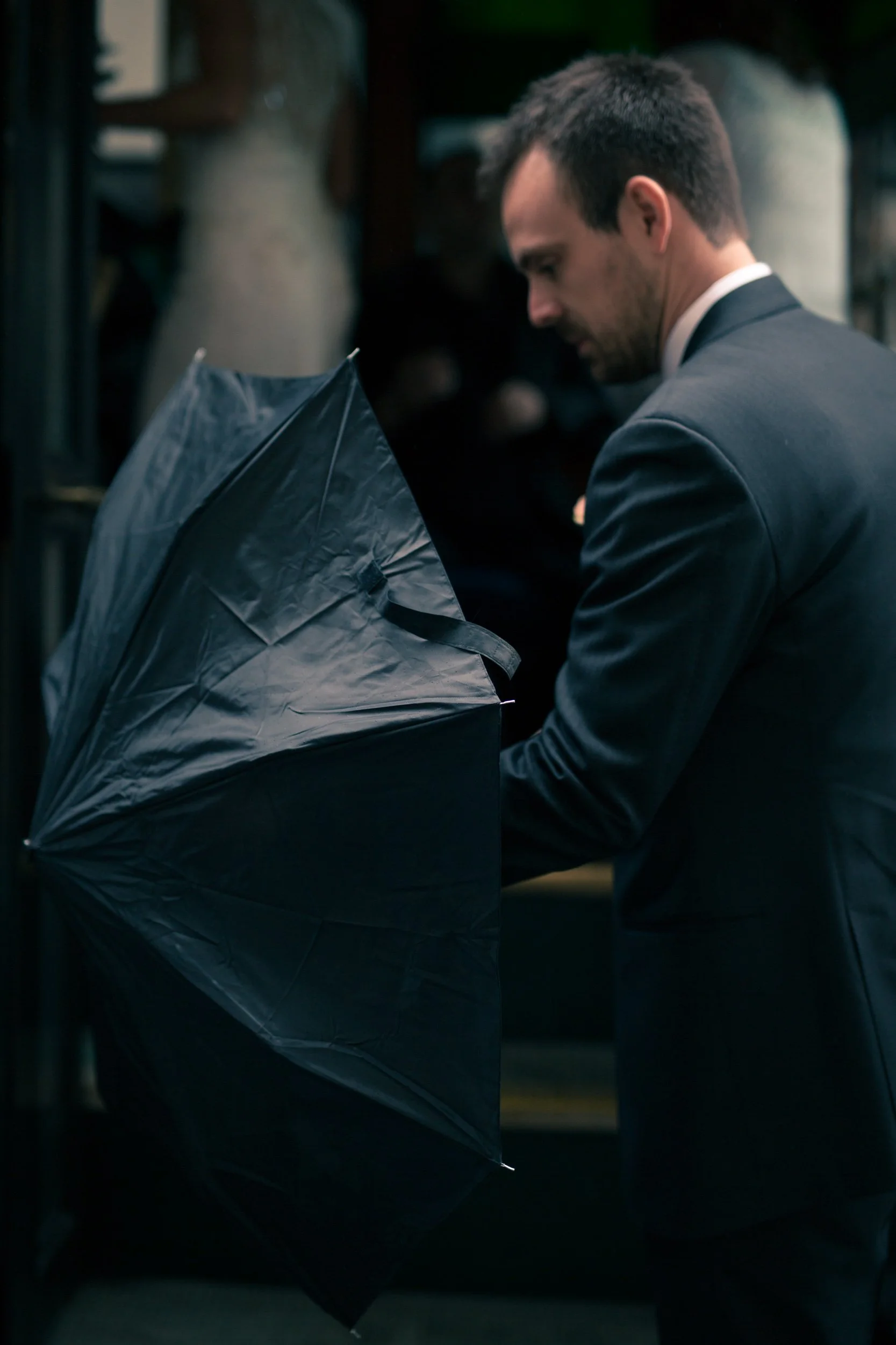 wedding groom with umbrella in the rain Chicago wedding photographer near me 