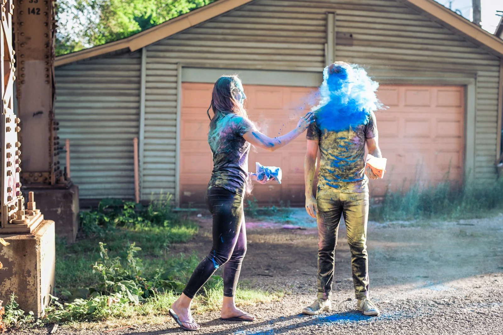 blue holi powder engagement photo session under el track Chicago wedding photographer near me
