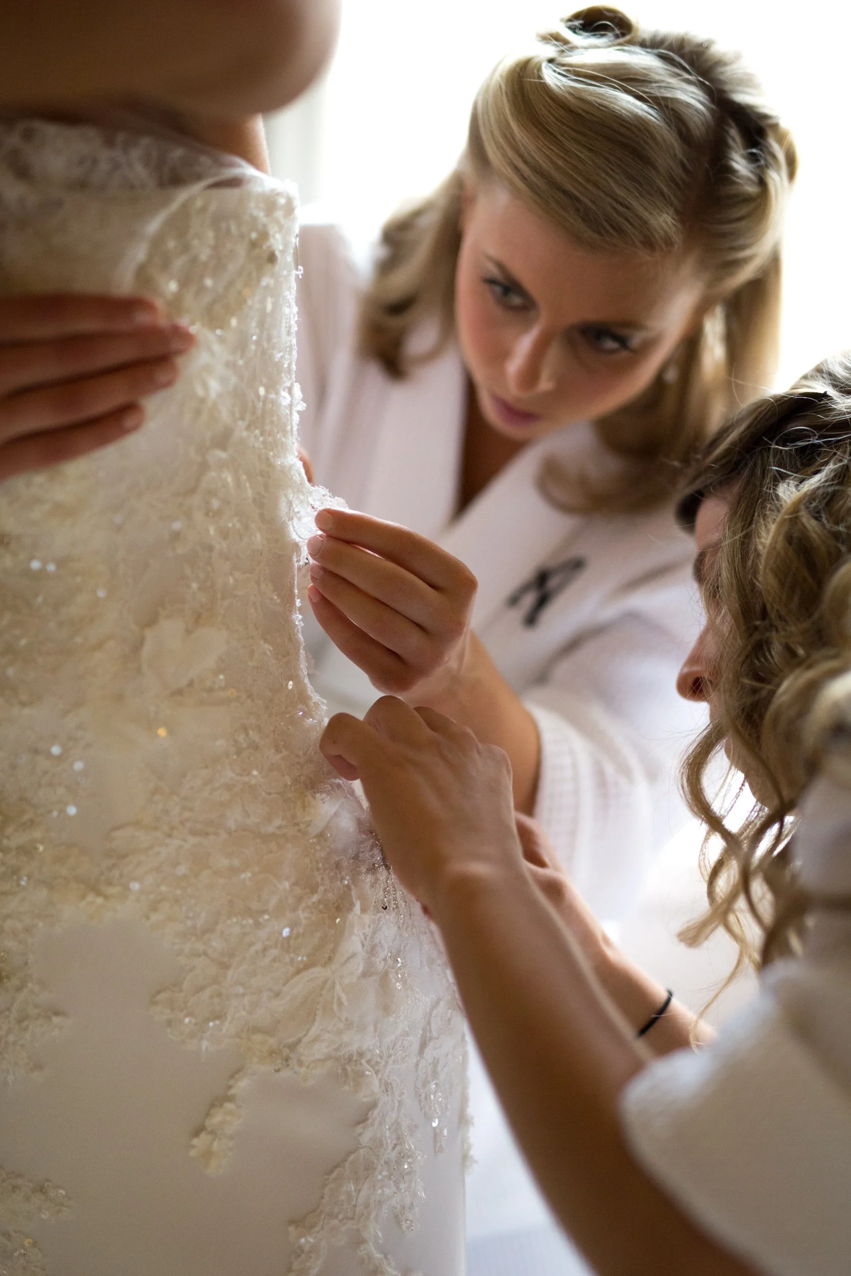 bride getting dressed near a window Chicago wedding photography