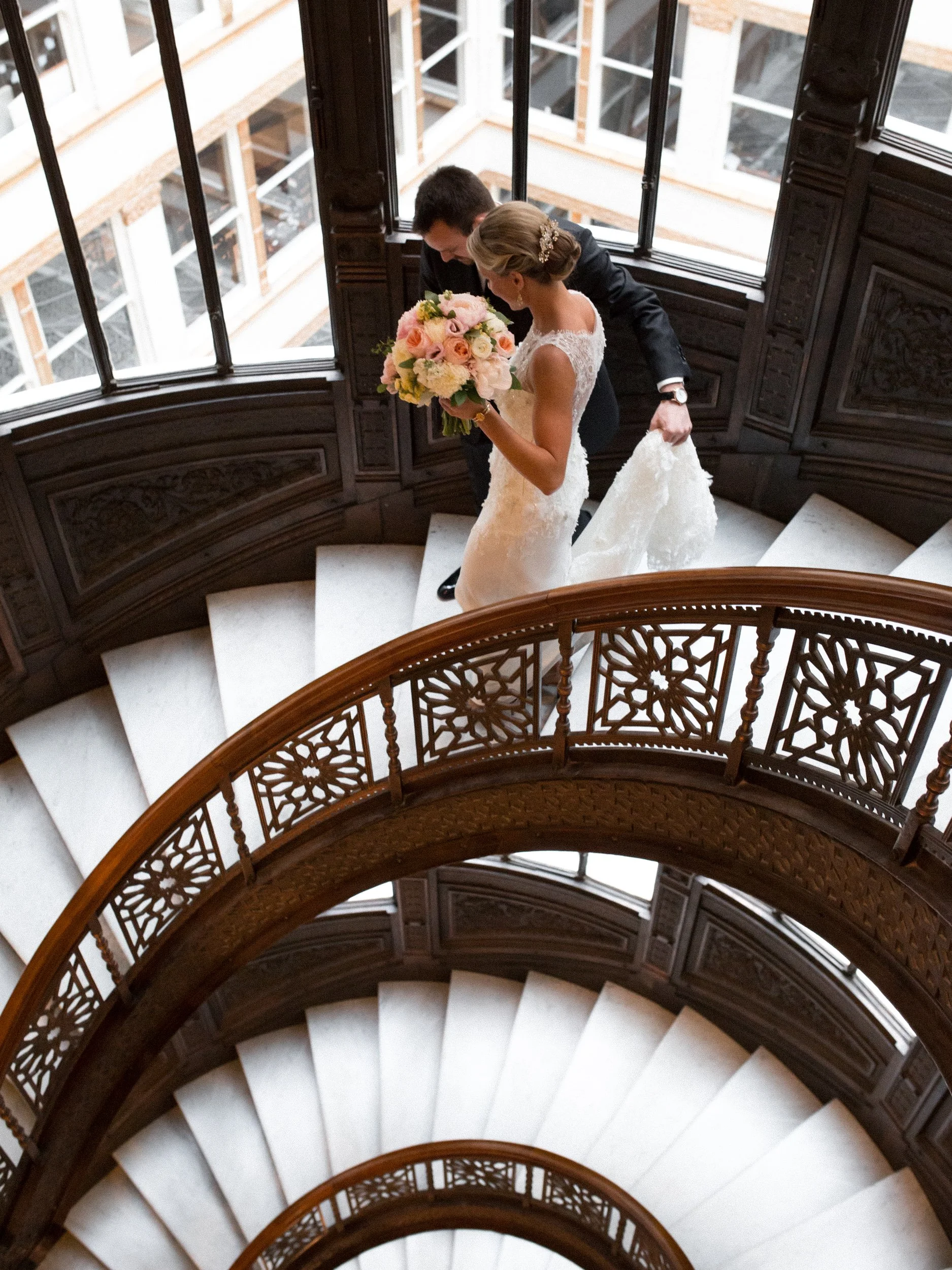 bride and groom walking down stairs The Rookery classic Chicago wedding photographer near me