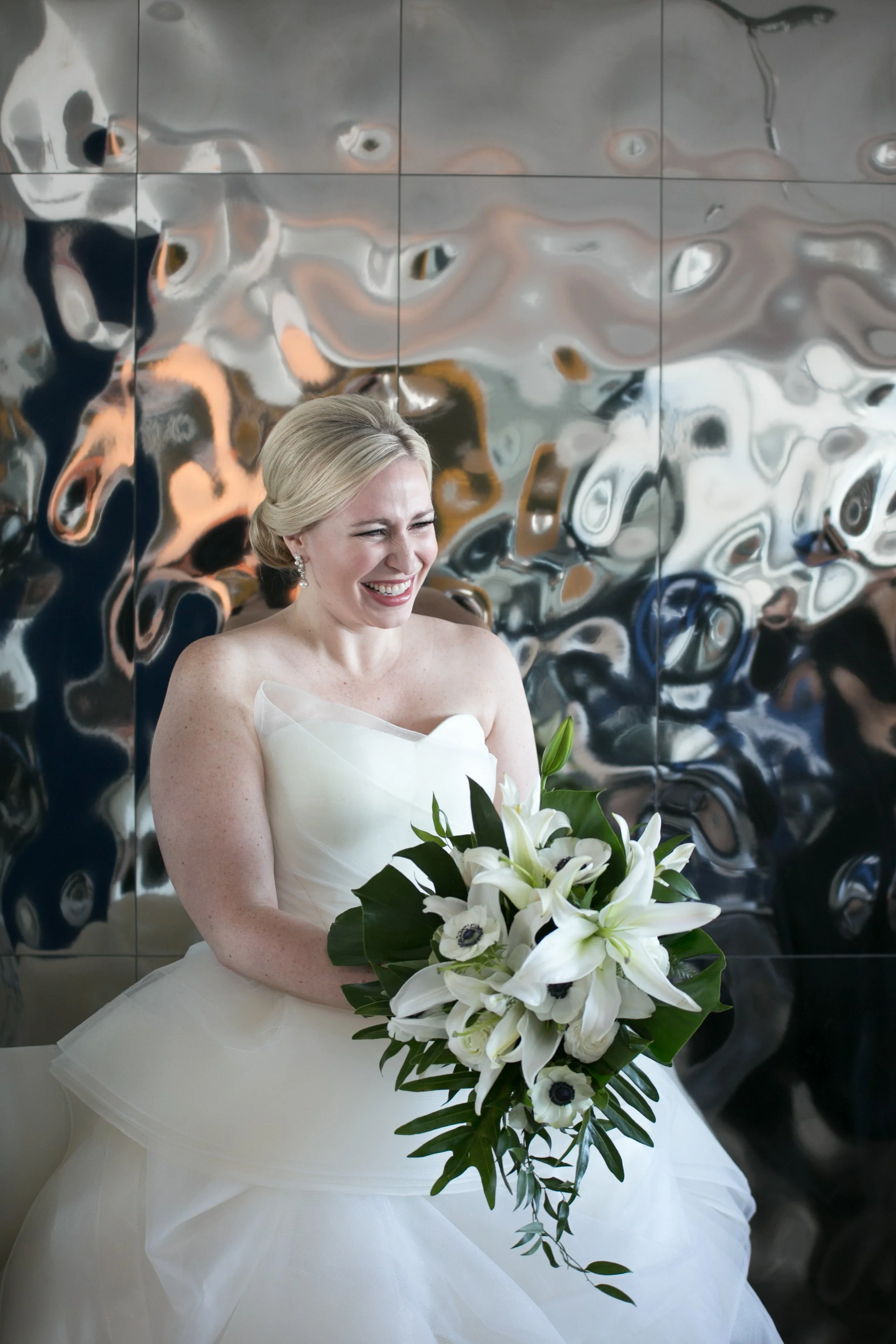 bride getting dressed smiling with flowers average price for wedding photographer