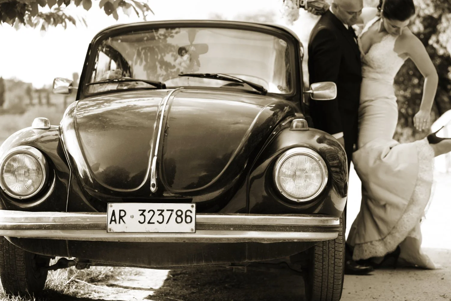Regal wedding couple in front of a car after their ceremony. Wedding photo library.